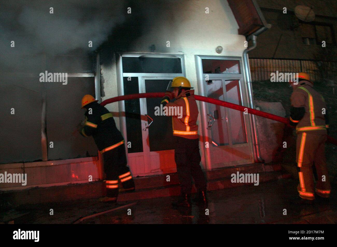 Firefighters try to extinguish fire in a shop in Kosovo's ethnically divided town of Mitrovica December 30, 2008. Hundreds of Kosovo Serbs destroyed several Albanian shops in the flashpoint town of Mitrovica on Tuesday after a Serb teenager was injured in a street fight. Serbs gathered on the spot where the boy was hurt by two knife-wielding Albanian teenagers, setting several shops on fire and destroying cars with Kosovo licence plates. REUTERS/Nebojsa Markovic (KOSOVO) Stock Photo