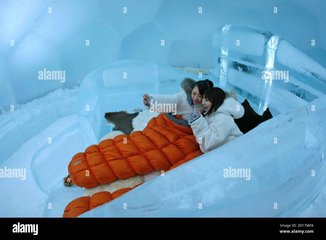 Women are pictured taking a self portrait on the bed of a ice hotel during  a photo opportunity in the Alpha Resort-Tomamu's ice village in Shimukappu  town, Japan's northern island of Hokkaido