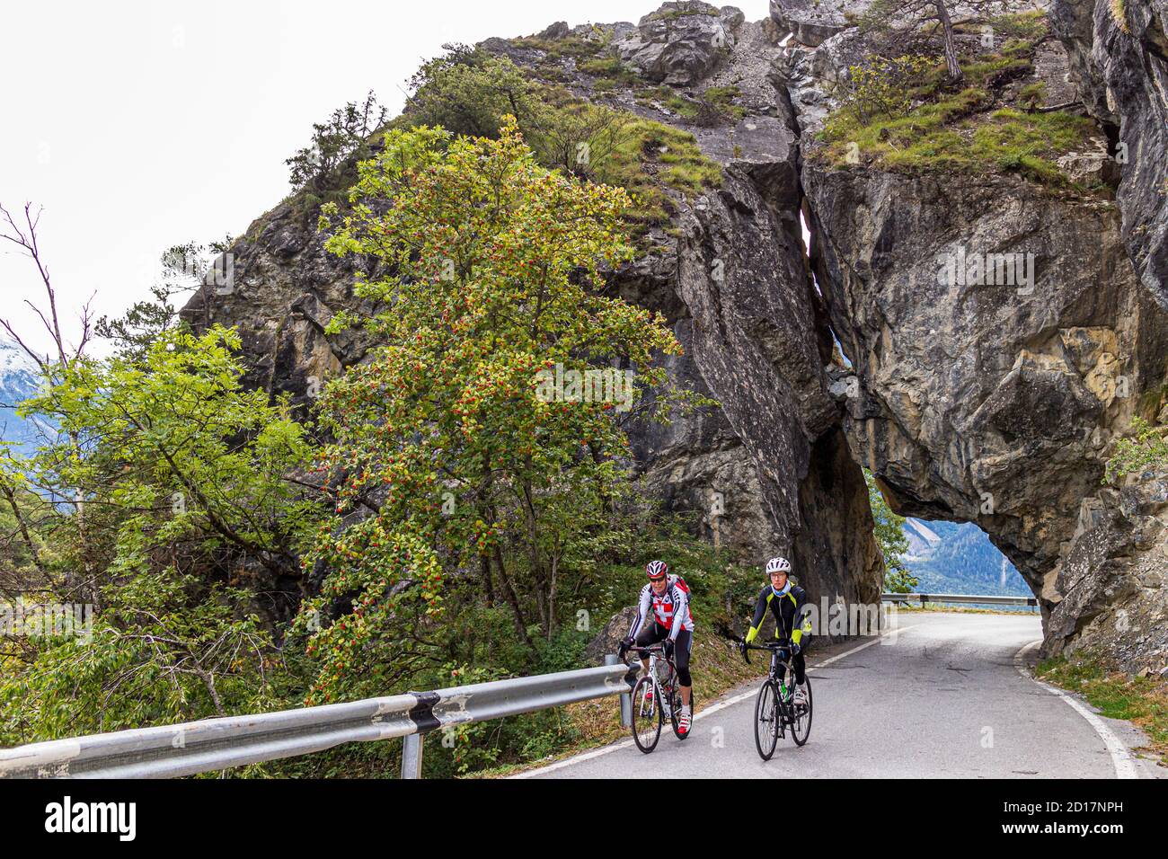 With racing bikes through the Alps at Leuk, Switzerland. With the racing bike over the asphalt. Sports student Julius Berg on the road with bike guide Roland Holzer from Albinen. Stock Photo