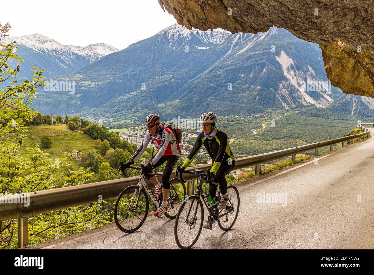 With racing bikes through the Alps at Leuk, Switzerland. With the racing bike over the asphalt. Sports student Julius Berg on the road with bike guide Roland Holzer from Albinen. Stock Photo