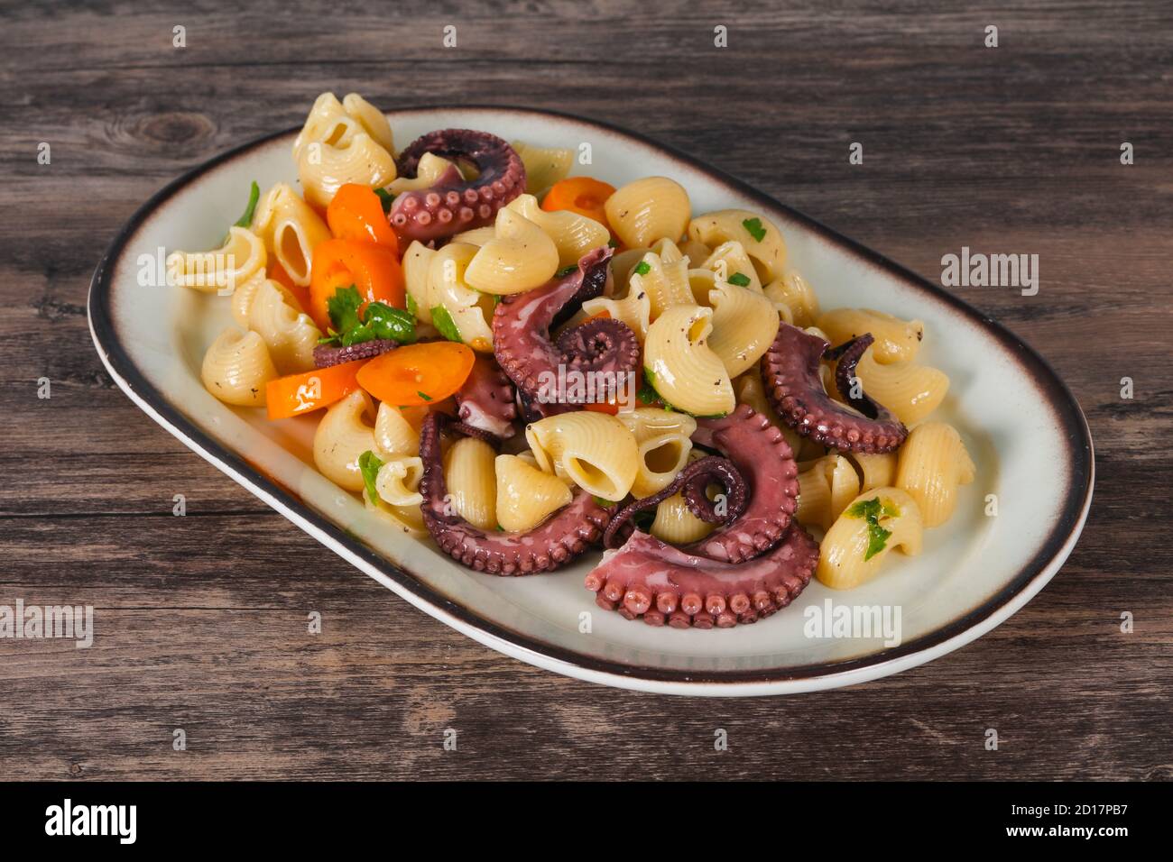Pasta with octopus, parsley and yellow tomatoes Stock Photo - Alamy