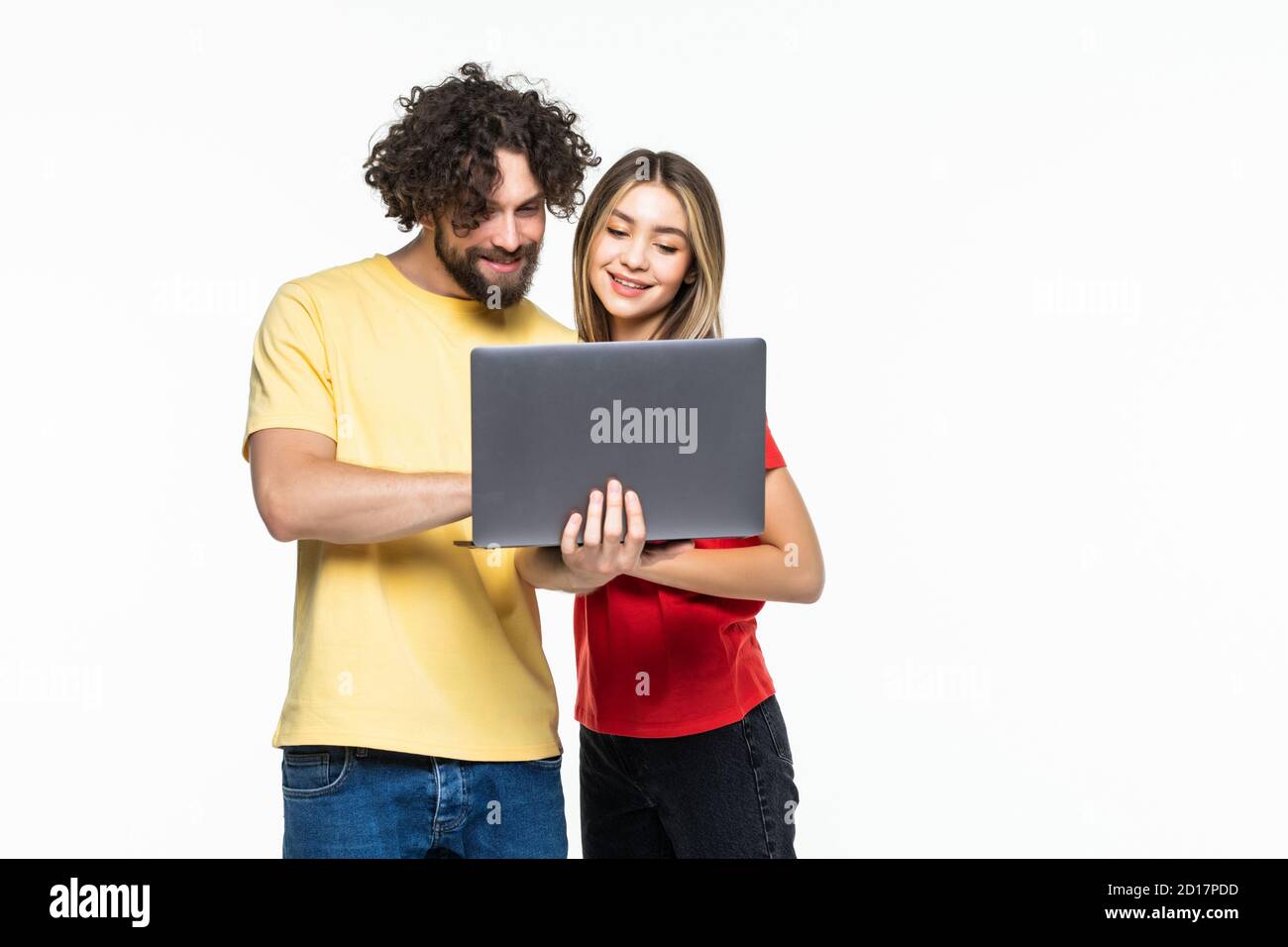 Attractive young couple holding their laptop on white background Stock ...