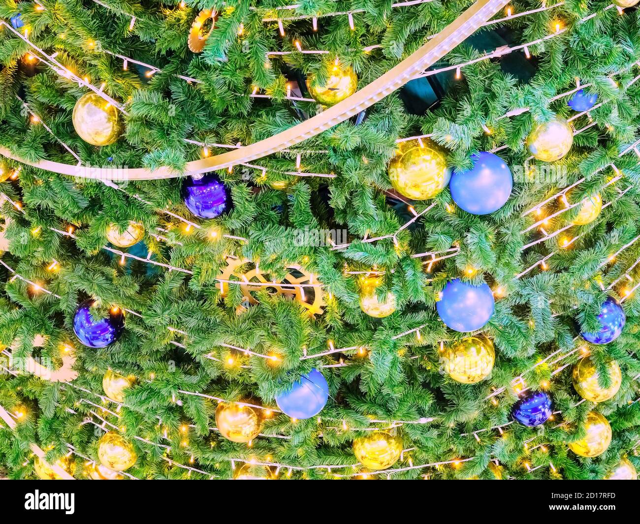 Christmas tree decorated with garlands and golden and blue balls Stock ...