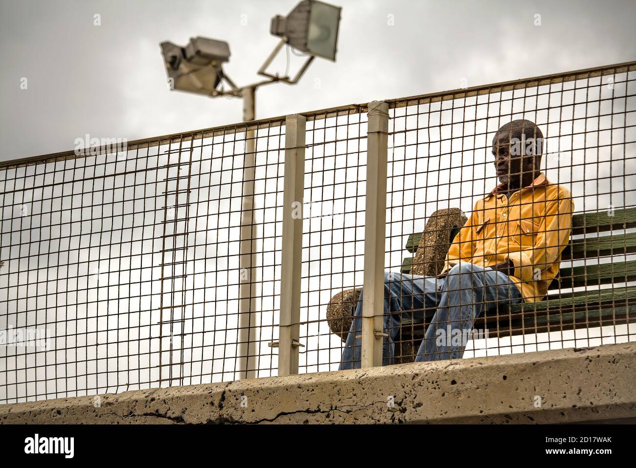 Muizenberg, Cape Town, Sudafrica - 31 DECEMBER 2017: portrait of a reflective black man waiting behind a barrier Stock Photo