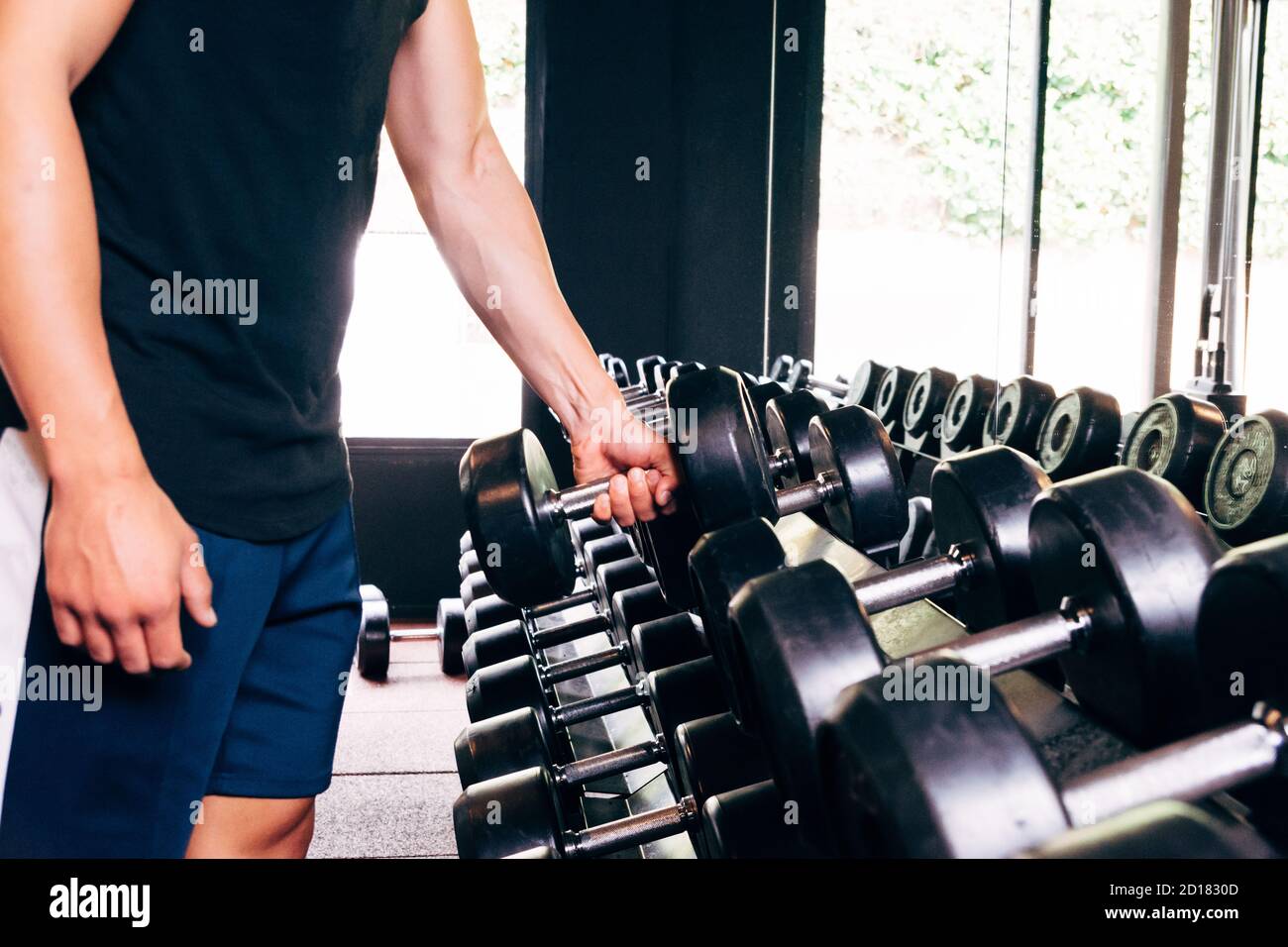 unrecognizable man holding a weight in the gym Stock Photo