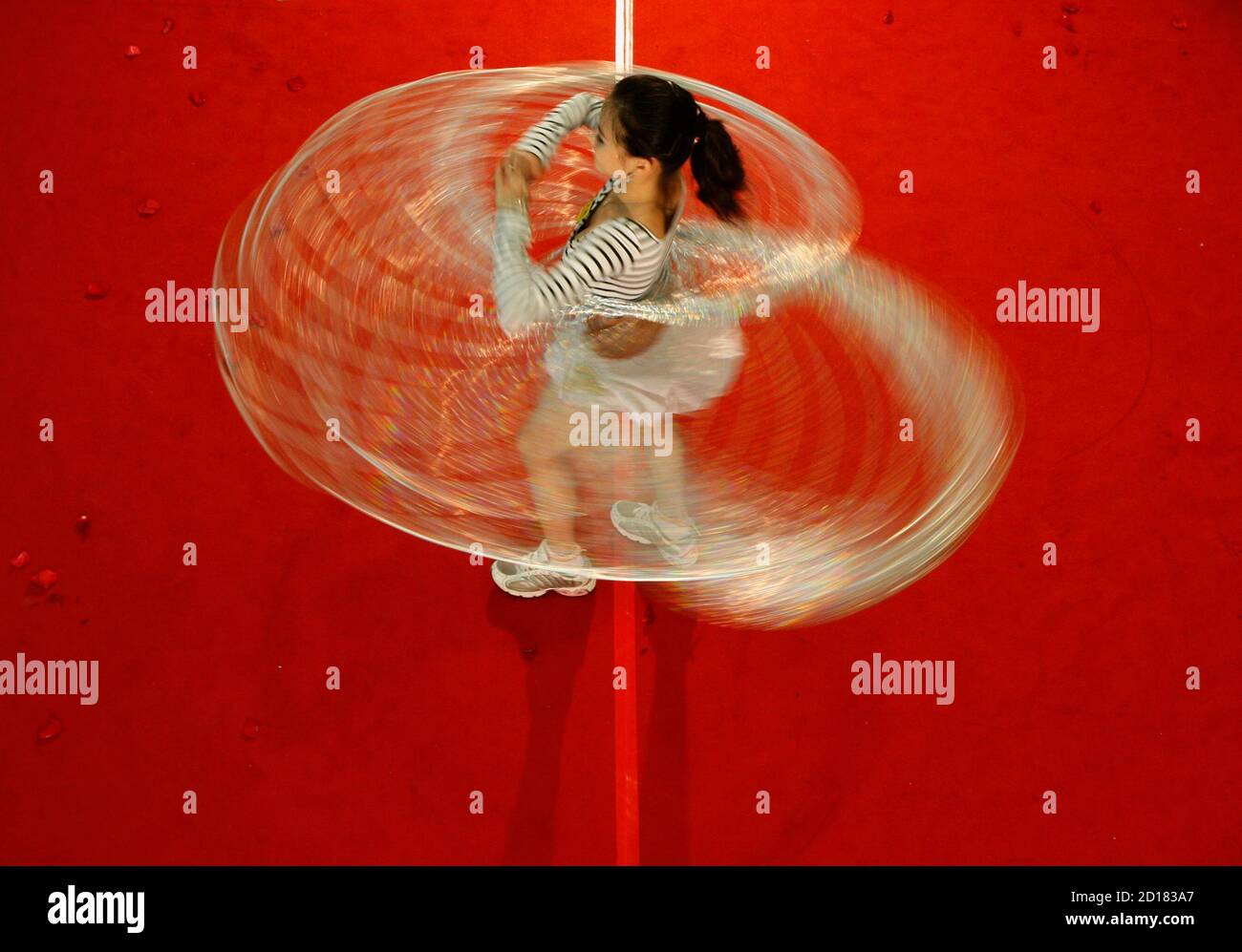 A member from one of China's Beijing Olympic Games cheerleading squards  swings hula hoops during a performance in Hong Kong April 22, 2008, eight  days before the Olympic torch arrives there. REUTERS/Bobby