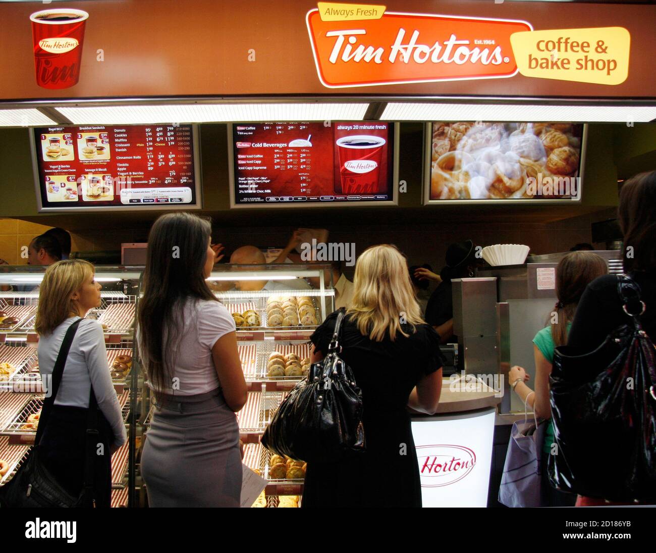 Customers wait at a Tim Hortons coffee and bake shop at Penn Station in New  York July 13, 2009. Tim Hortons Inc. today began serving its coffee, baked  goods and soups and