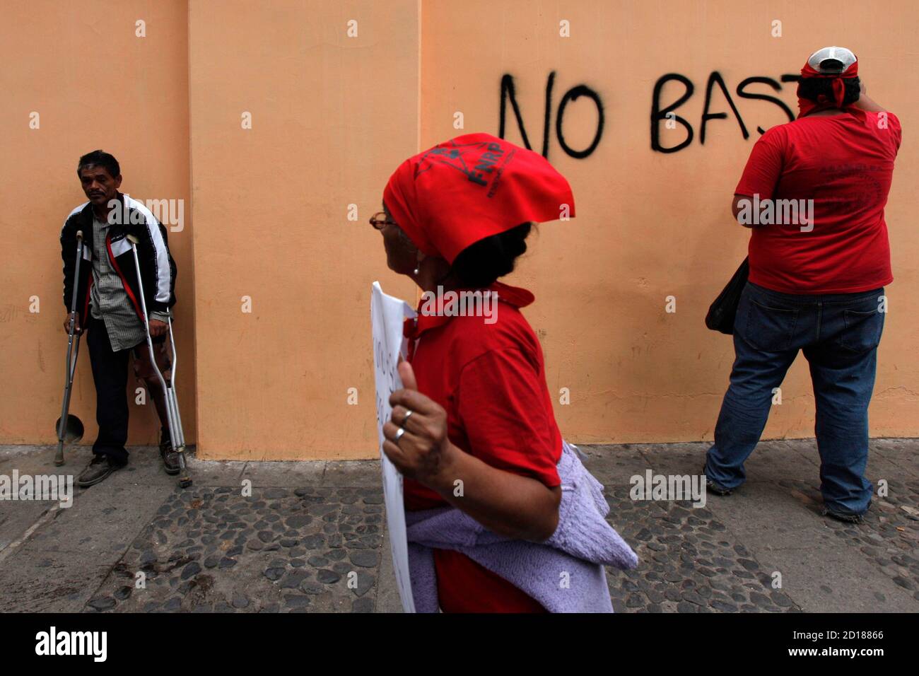 A supporter Honduras' ousted President Manuel Zelaya write on a wall "Not, enough" during a protest outside the National Congress, which is currently in session, in Tegucigalpa, January 7, 2010. Zelaya supporters are protesting against Honduras leaving the ALBA alliance and a political amnesty law for all involved in the coup. REUTERS/Edgard Garrido (HONDURAS - Tags: CIVIL UNREST POLITICS) Stock Photo
