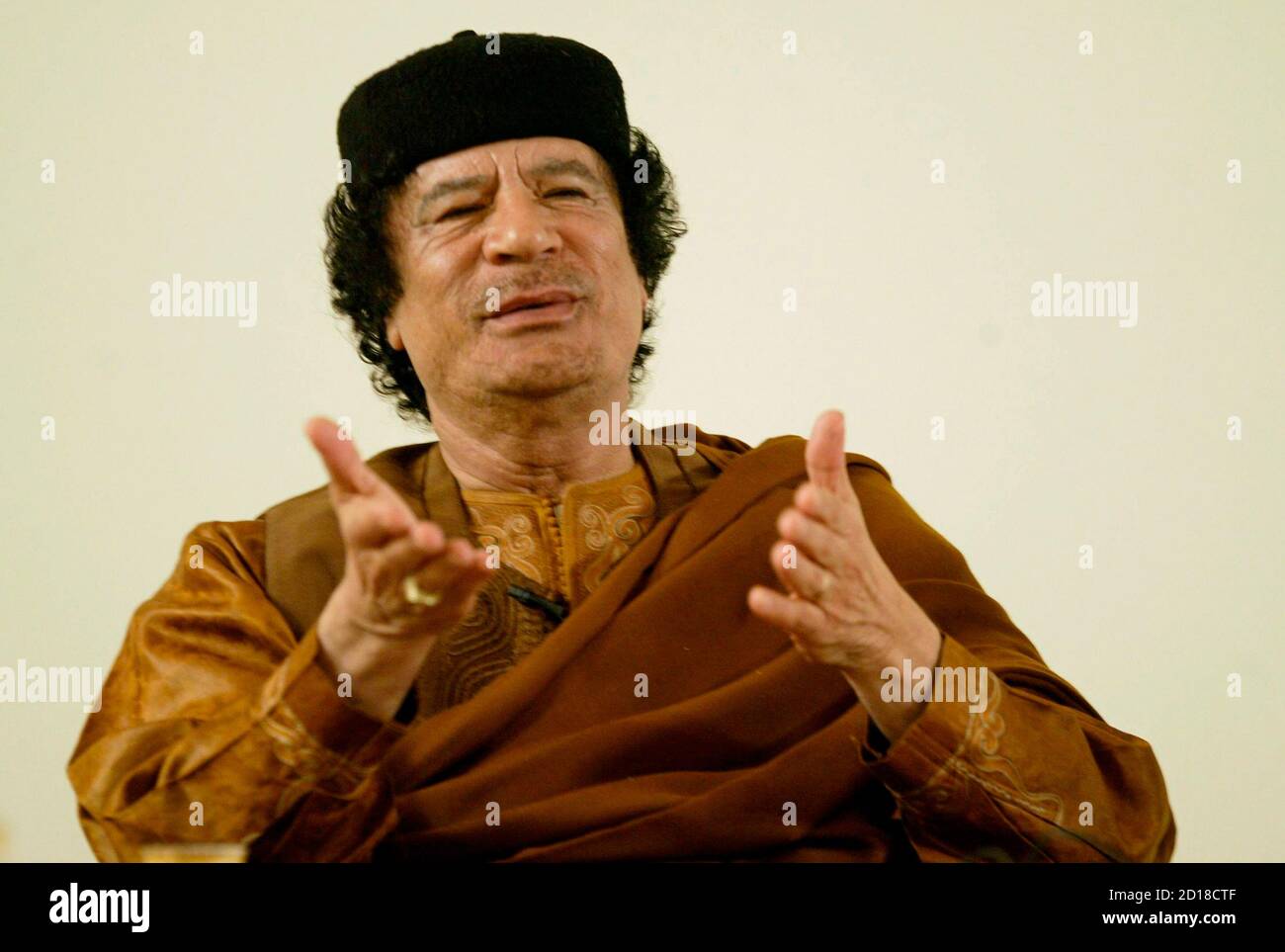 Libyan leader Muammar Gaddafi gestures during his debate with two Western scholars in the desert in Sebha March 2, 2007, in a move apparently designed to further the resumption of international ties following years of isolation. Speaking on the 30th anniversary of his declaration of a Jamahiriyah or state of the masses, Gaddafi said Libya was embracing globalisation and the outside world after years of sanctions but insisted his experiment in rule by town hall meetings was fairer than the West's ballot box democracy. REUTERS/Louafi Larbi (LIBYA) Stock Photo