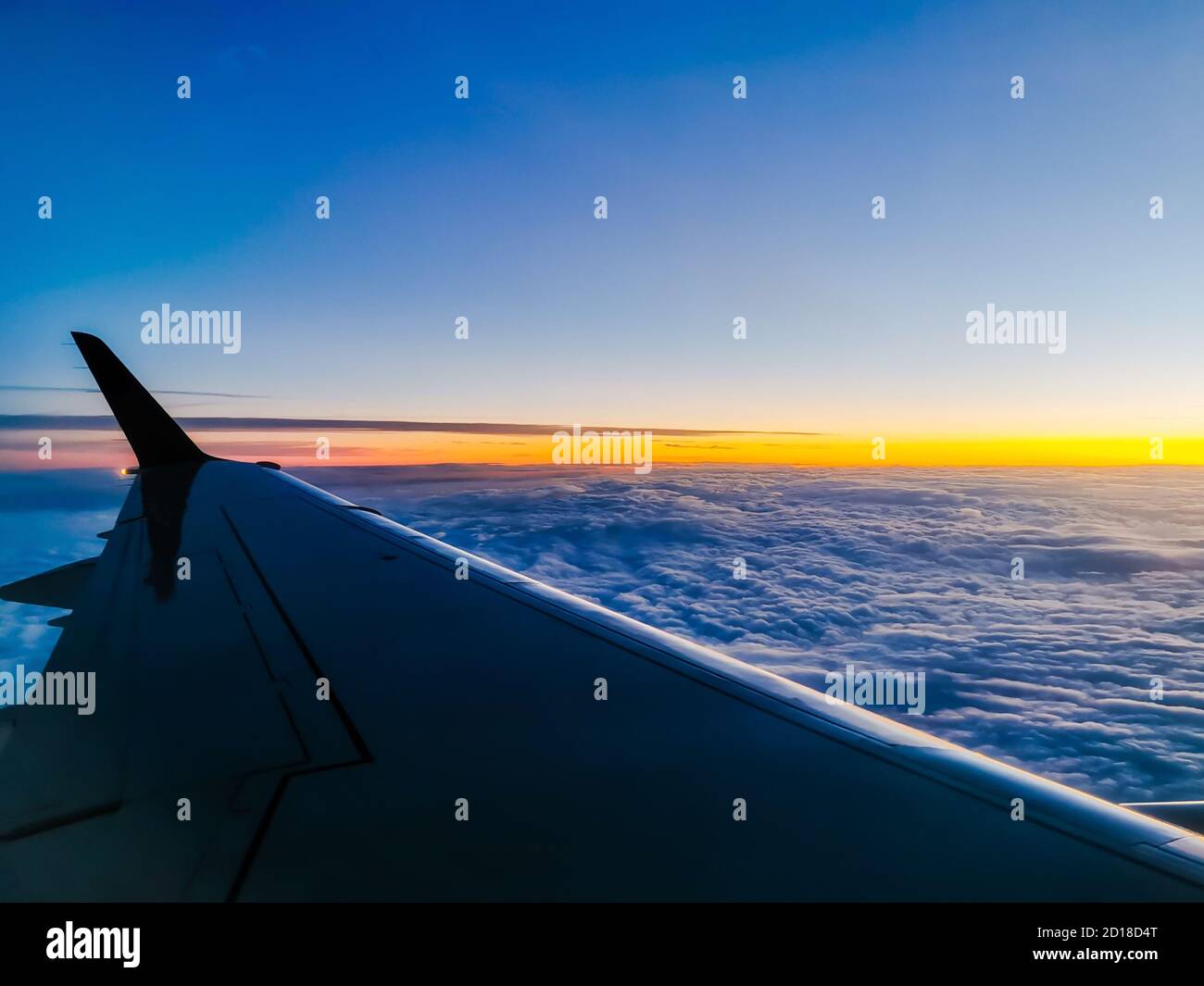 Wing of a plane flying above the cloudy sky during the sunset - perfect ...