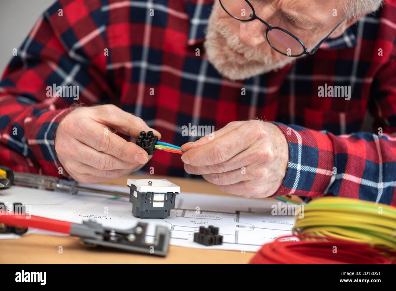 Senior electrician connecting wires in terminal block Stock Photo