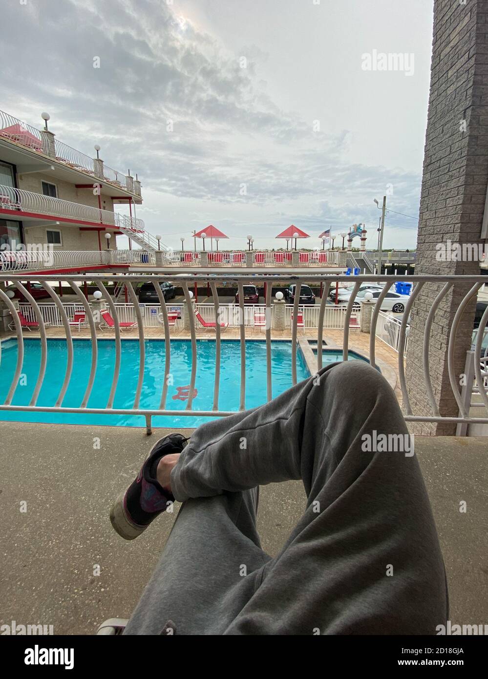 The Crossed Legs of a Man Relaxing at an Oceanfront Resort Stock Photo