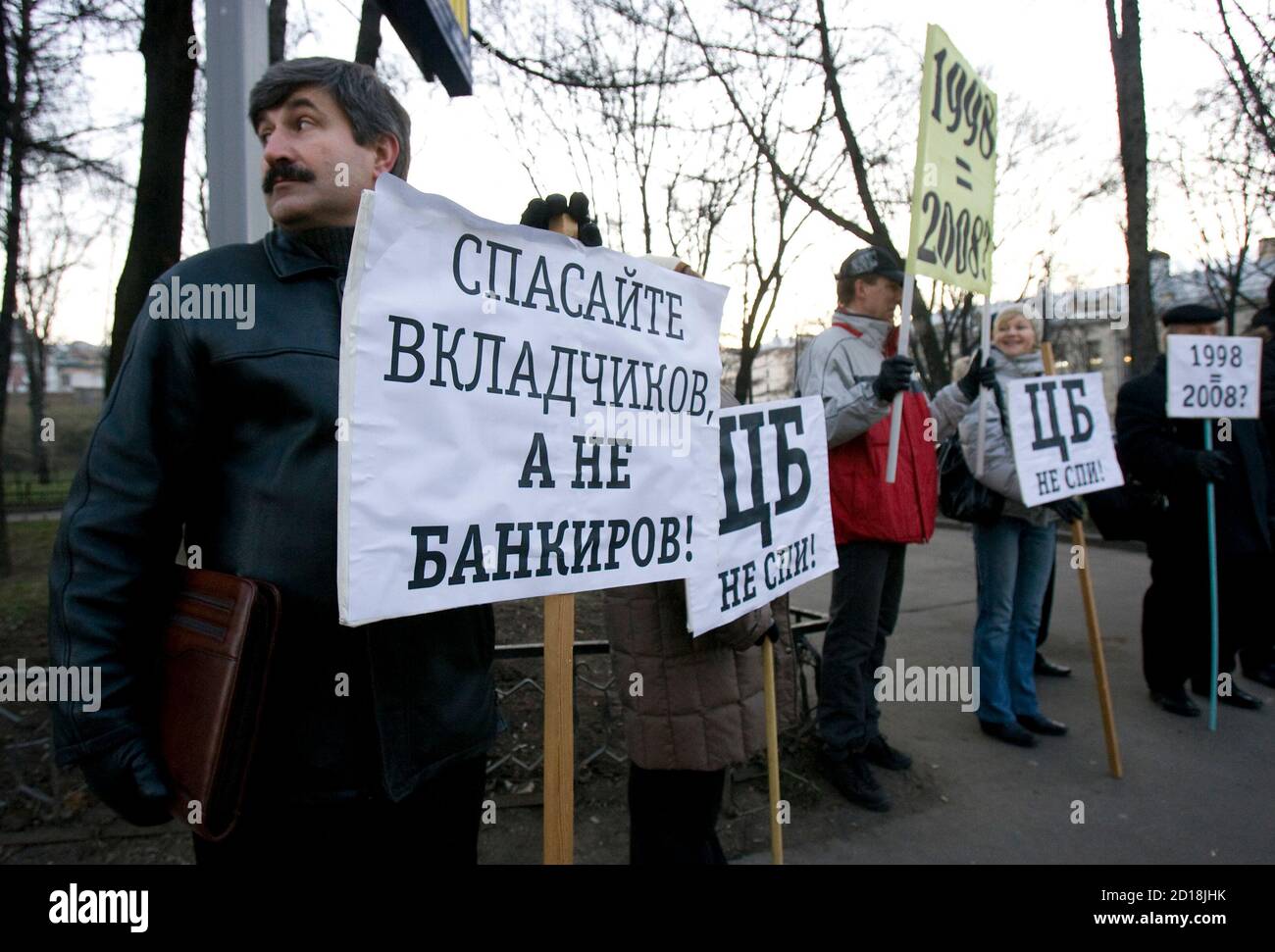 Investors of the bank Kapital Kredit stand with placards reading (L-R) 'Save Investors, Not Bankers', 'Central Bank, Wake Up!' and '1998 (Crisis) equals 2008' during a picket in front of the main building in Moscow, December 19, 2008. Bank investors gathered to claim their money from the bank.  REUTERS/Sergei Karpukhin  (RUSSIA) Stock Photo