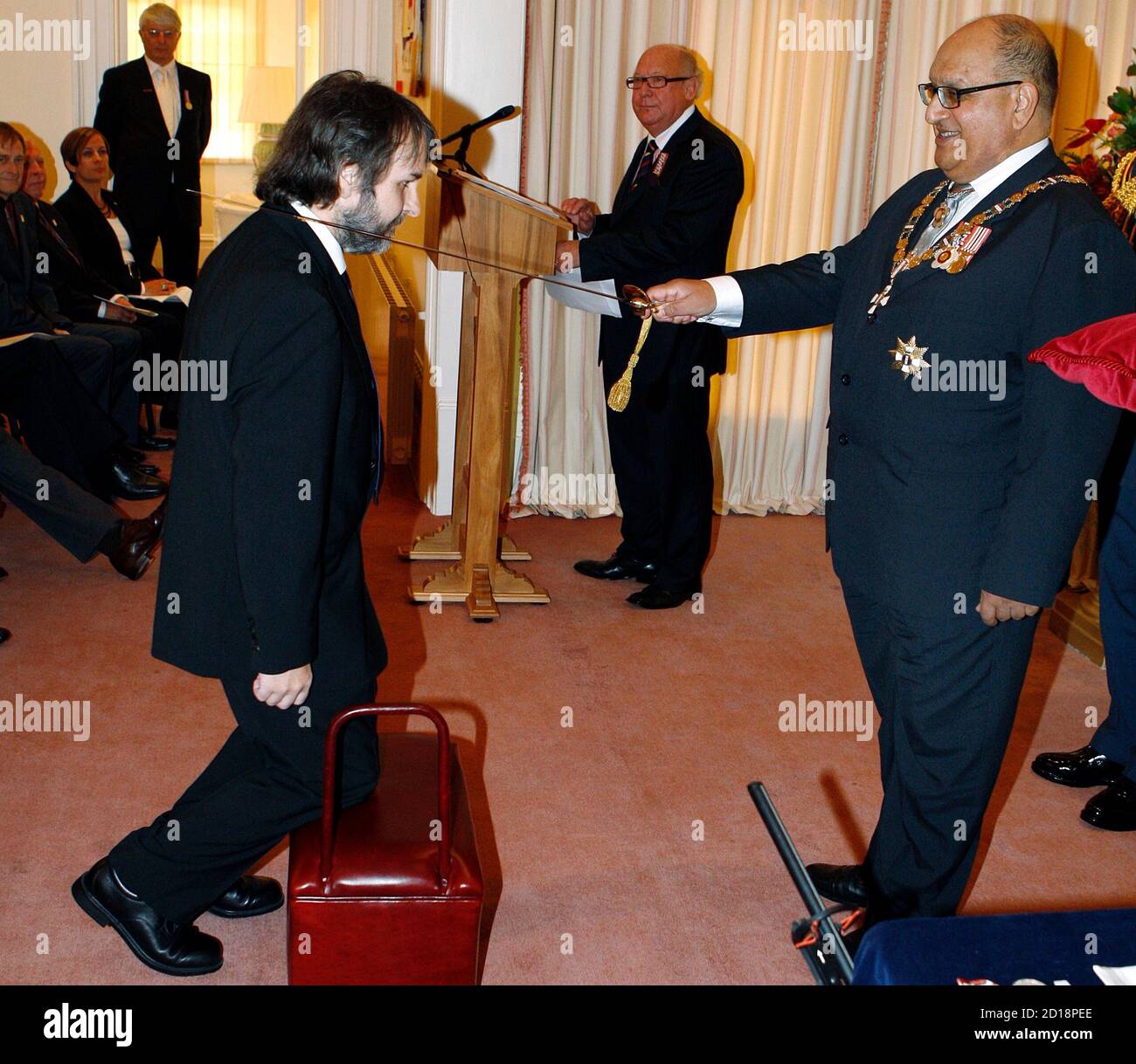 Director Peter Jackson (L) of New Zealand is knighted by New Zealand's Governor-General Anand Satyanand at Premier House in Wellington April 28, 2010. Jackson who directed the 'Lord Of The Rings' trilogy, received the Knight Companion of the New Zealand Order of Merit, for services to the arts. REUTERS/Dominion Post/ Kent Blechynden/Pool (NEW ZEALAND - Tags: ENTERTAINMENT POLITICS) Stock Photo