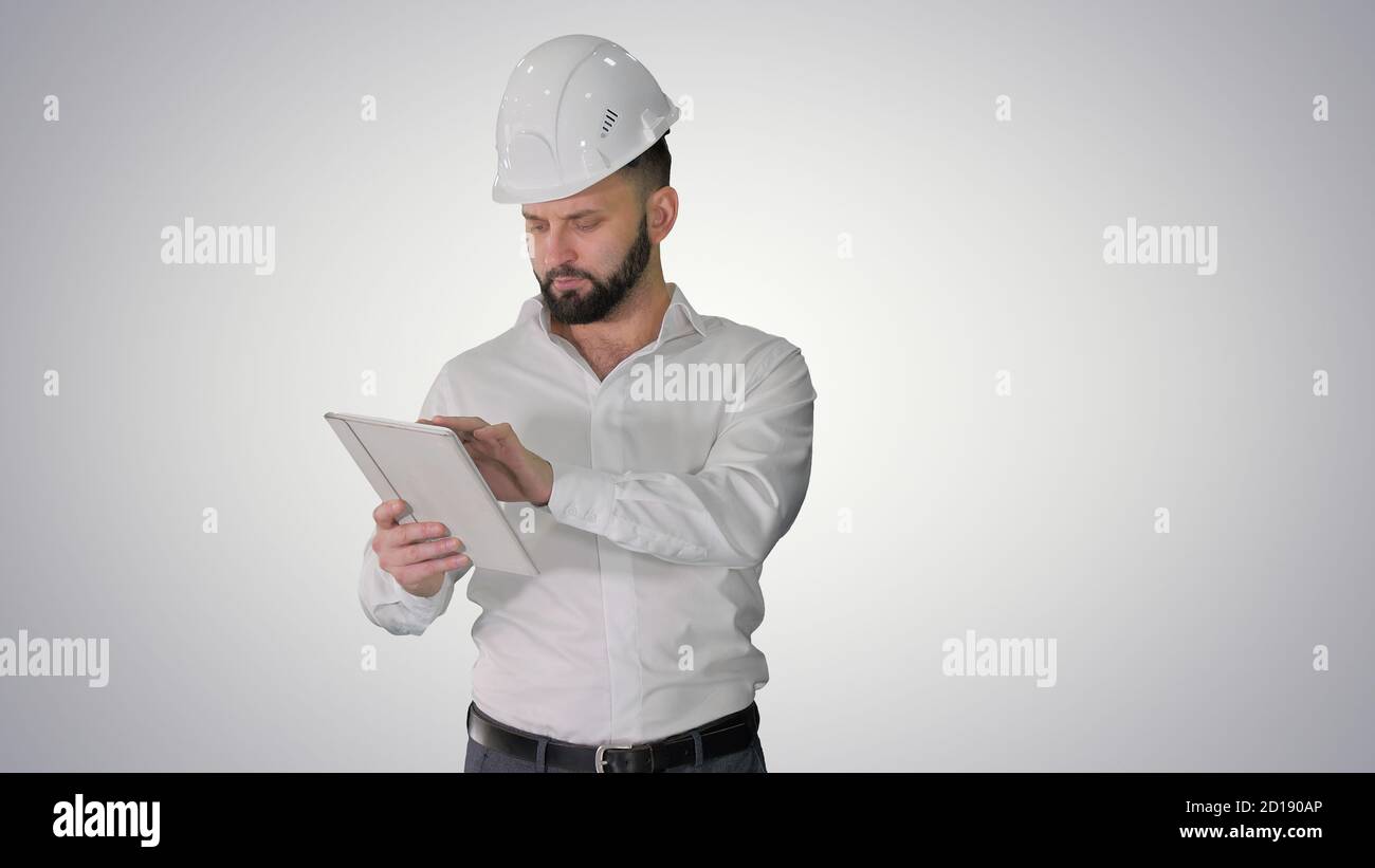 Construction specialist using a tablet computer while walking on Stock Photo