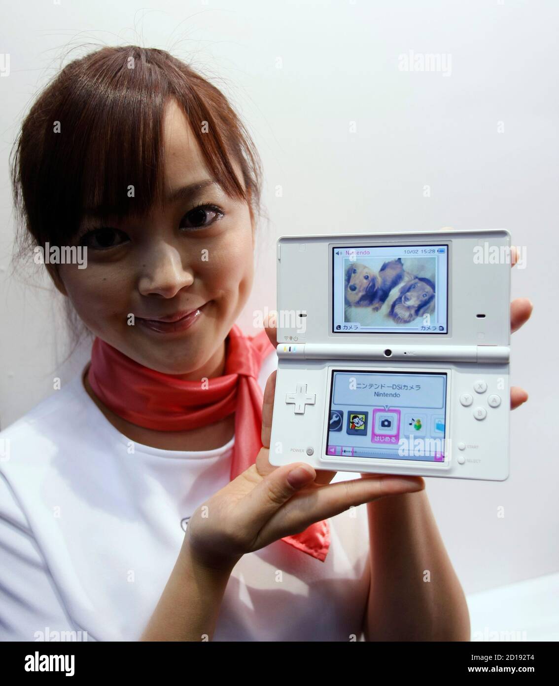 A promoter for Nintendo Co Ltd poses with the new DS handheld game console  after a news conference in Tokyo October 2, 2008. Japanese video game maker  Nintendo said on Thursday it