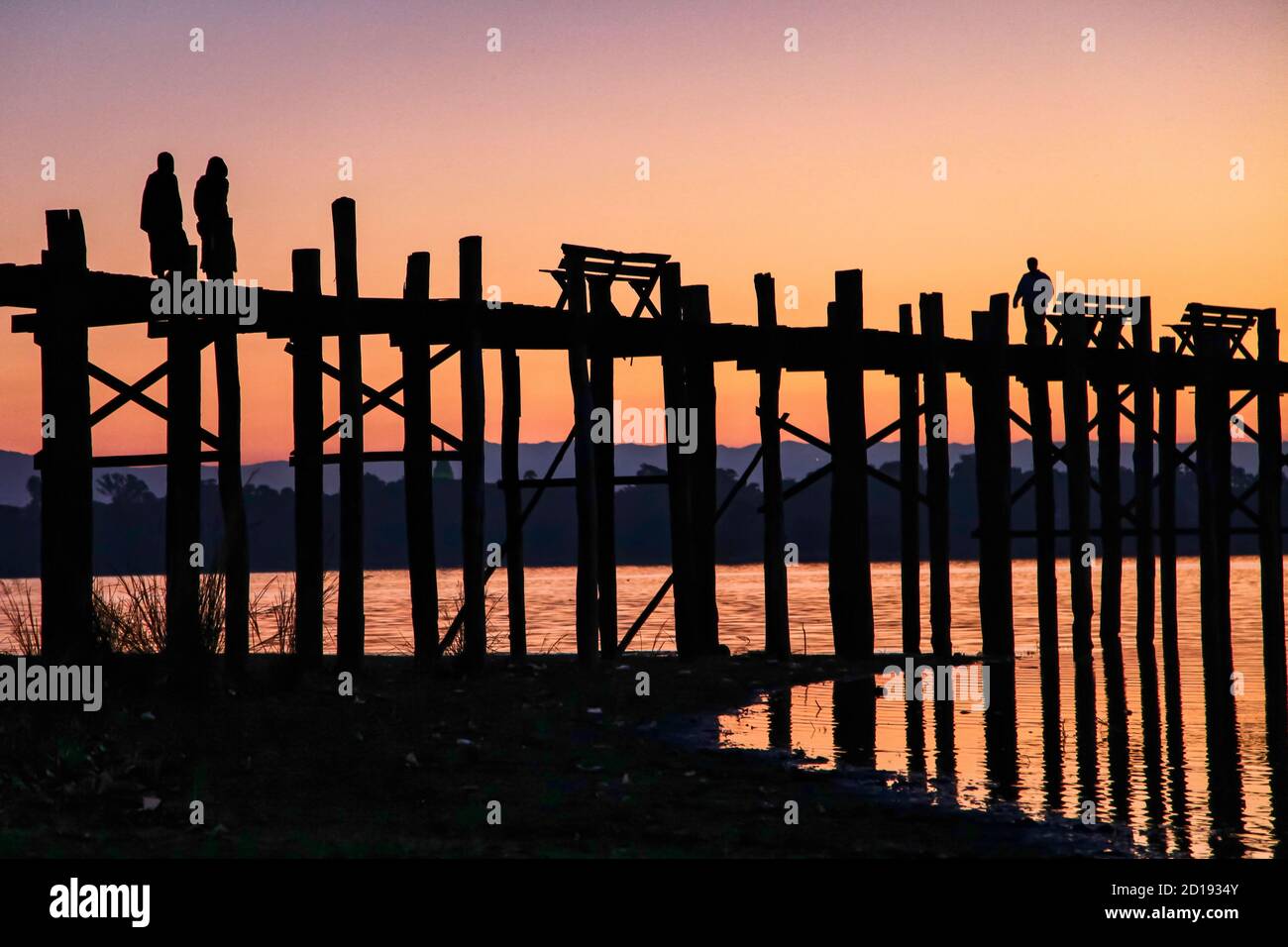 Silhouette of U Bein Bridge at sunrise. It is a crossing that spans ...