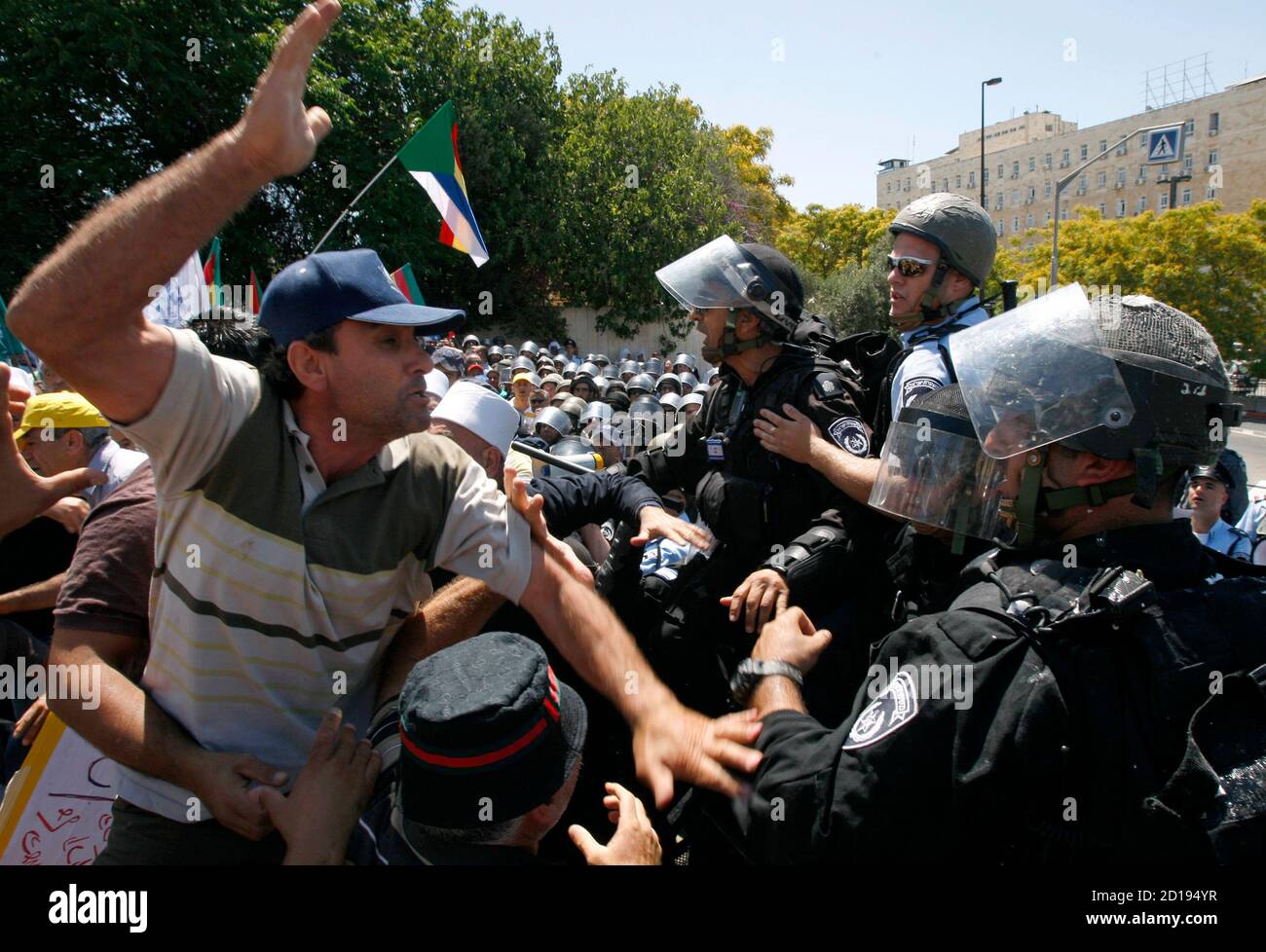 A protester raises his hand towards an Israeli police officer during scuffles in Jerusalem June 21, 2009. Hundreds of Israeli Druze and Circassians held a protest outside the Prime Minister's office in Jerusalem on Sunday against what they call unequal government funding for their communities. REUTERS/Baz Ratner (JERUSALEM POLITICS CONFLICT IMAGES OF THE DAY) Stock Photo