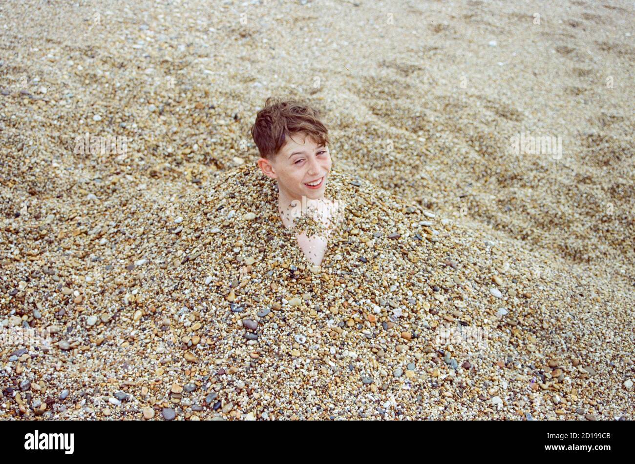 Twelve year old boy on Blackpool sands beach, Dartmouth, Devon, England, United Kingdom Stock Photo