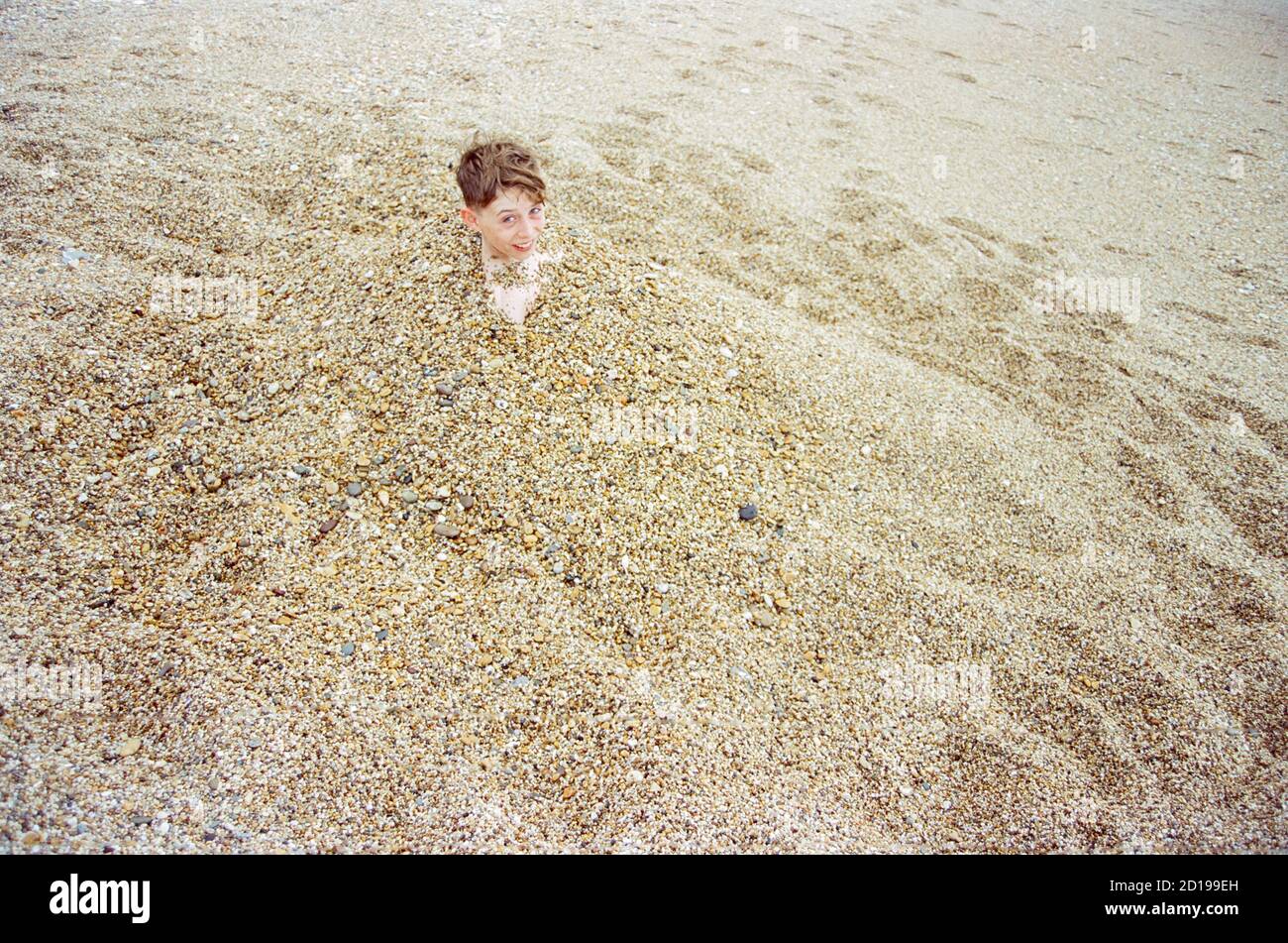 Twelve year old boy on Blackpool sands beach, Dartmouth, Devon, England, United Kingdom Stock Photo