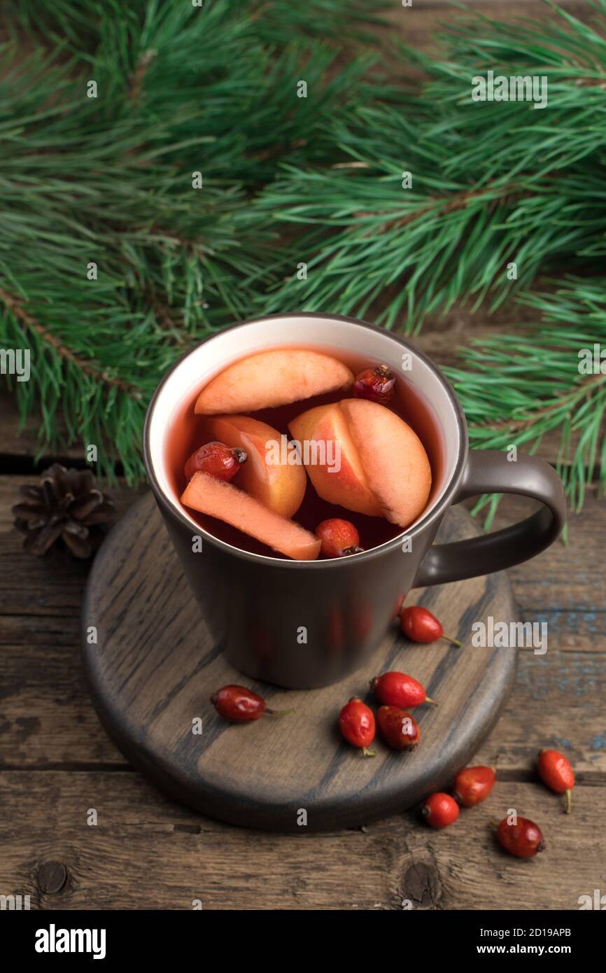 Brown Cup with mulled wine, berries and fir branches on a dark wooden background. Stock Photo