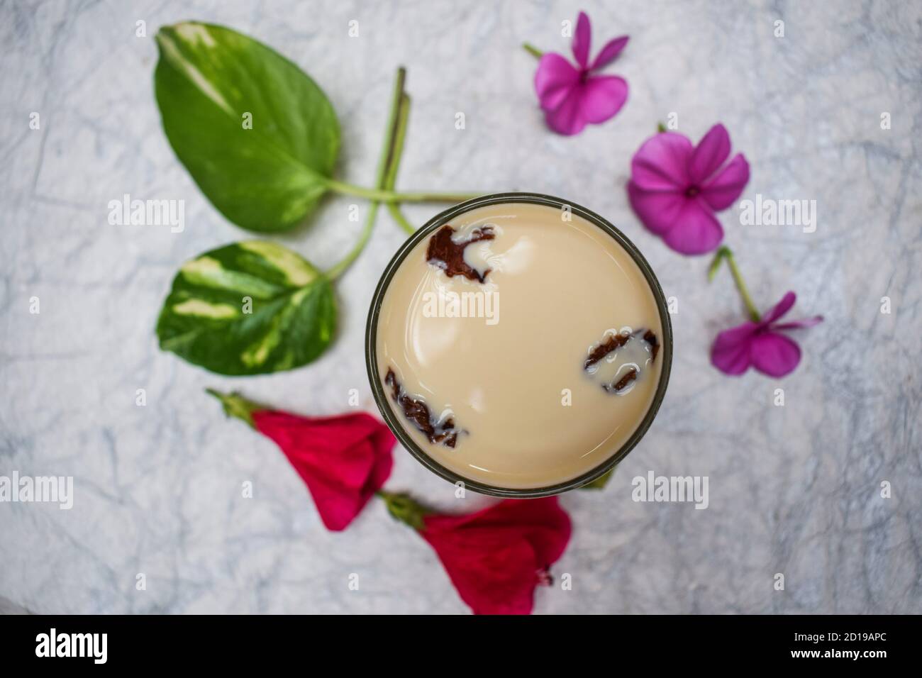 Flavoured Milk (badam milk), A preparation of Milk with Almond and saffron, dried rose petals. Decorated with flowers and leaves. Stock Photo