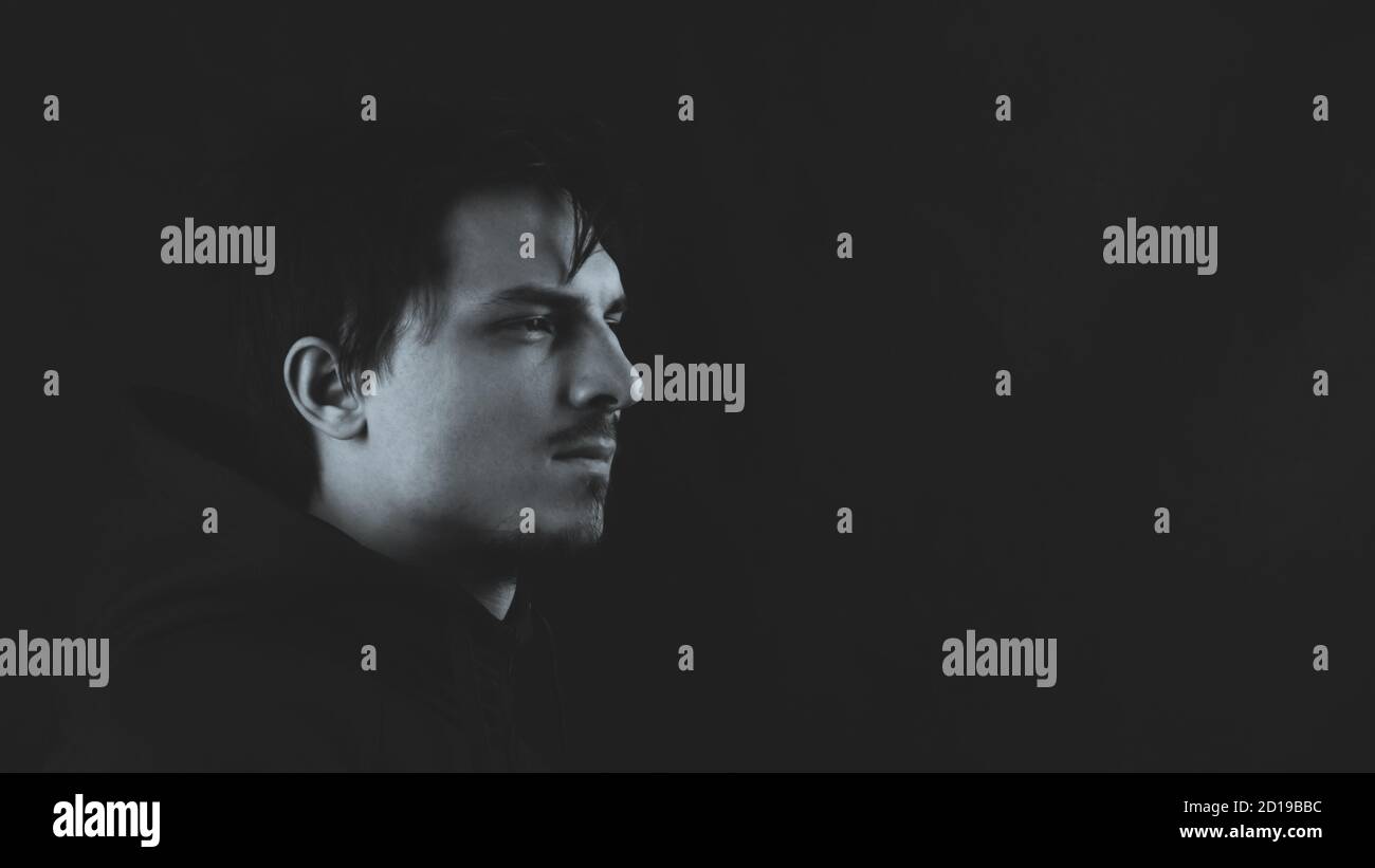 Profile view of young man in the dark. male portrait. black and white ...