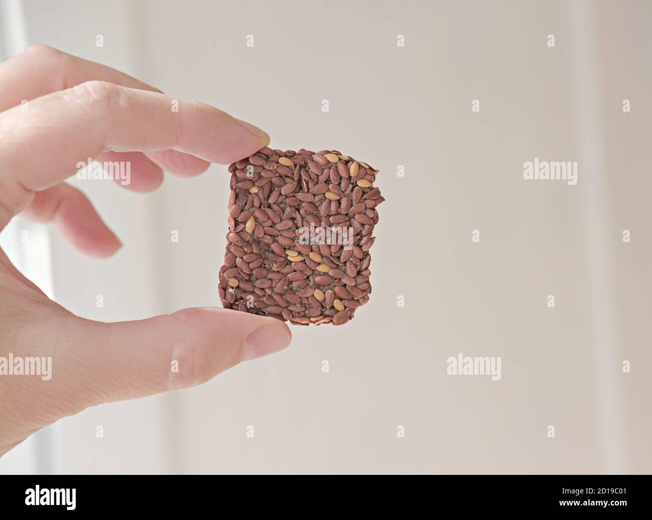 hand holding crunchy multigrain cereal flax seed crispbread. squares