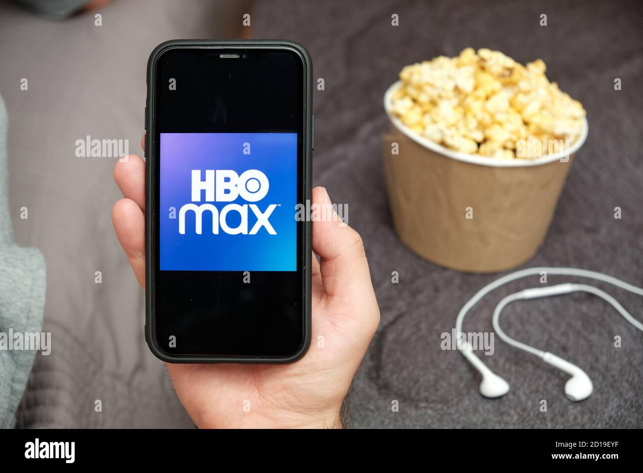 Close up mans hand holding a mobile phone with HBO Max logo with Apple ...