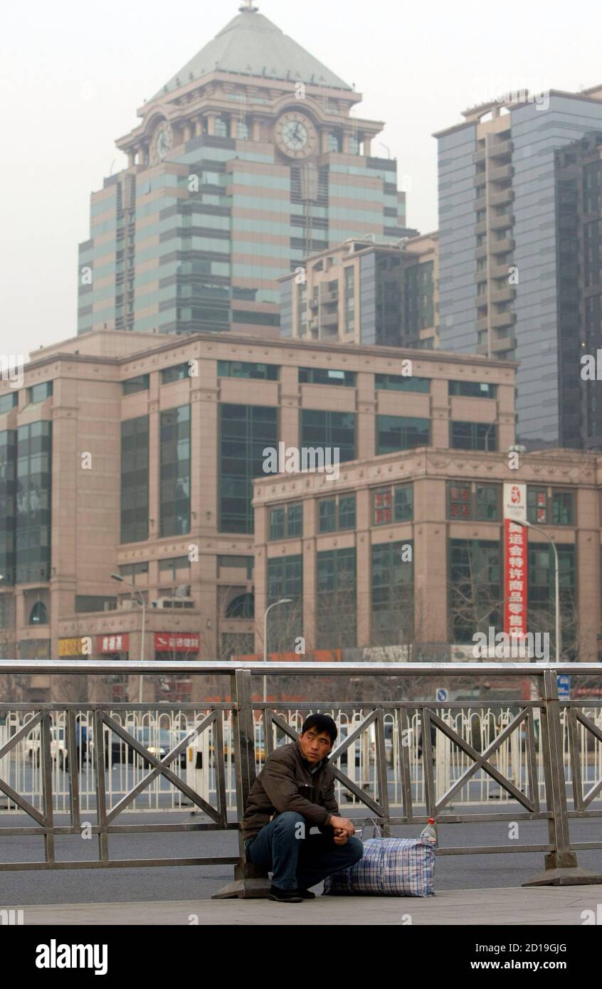 A migrant worker squats in the square of Beijing Railway Station December 9, 2008. China's job market will weaken to a two-year low in the first quarter of 2009 as the global financial crisis takes its toll, Manpower Inc said in a survey released on Tuesday. REUTERS/Jason Lee (CHINA) Stock Photo