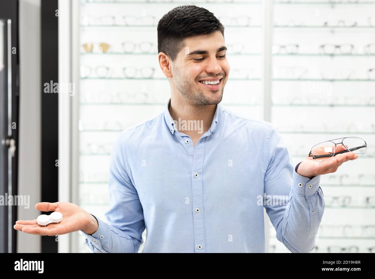 Thinking man choosing between eyeglasses and contacts Stock Photo