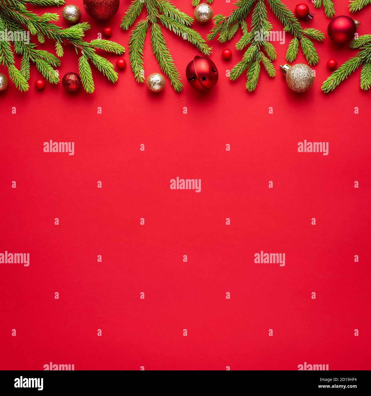 Square christmas card with fir decorations on red background/ Blank with copy space for advertising text. Top view, flat lay Stock Photo