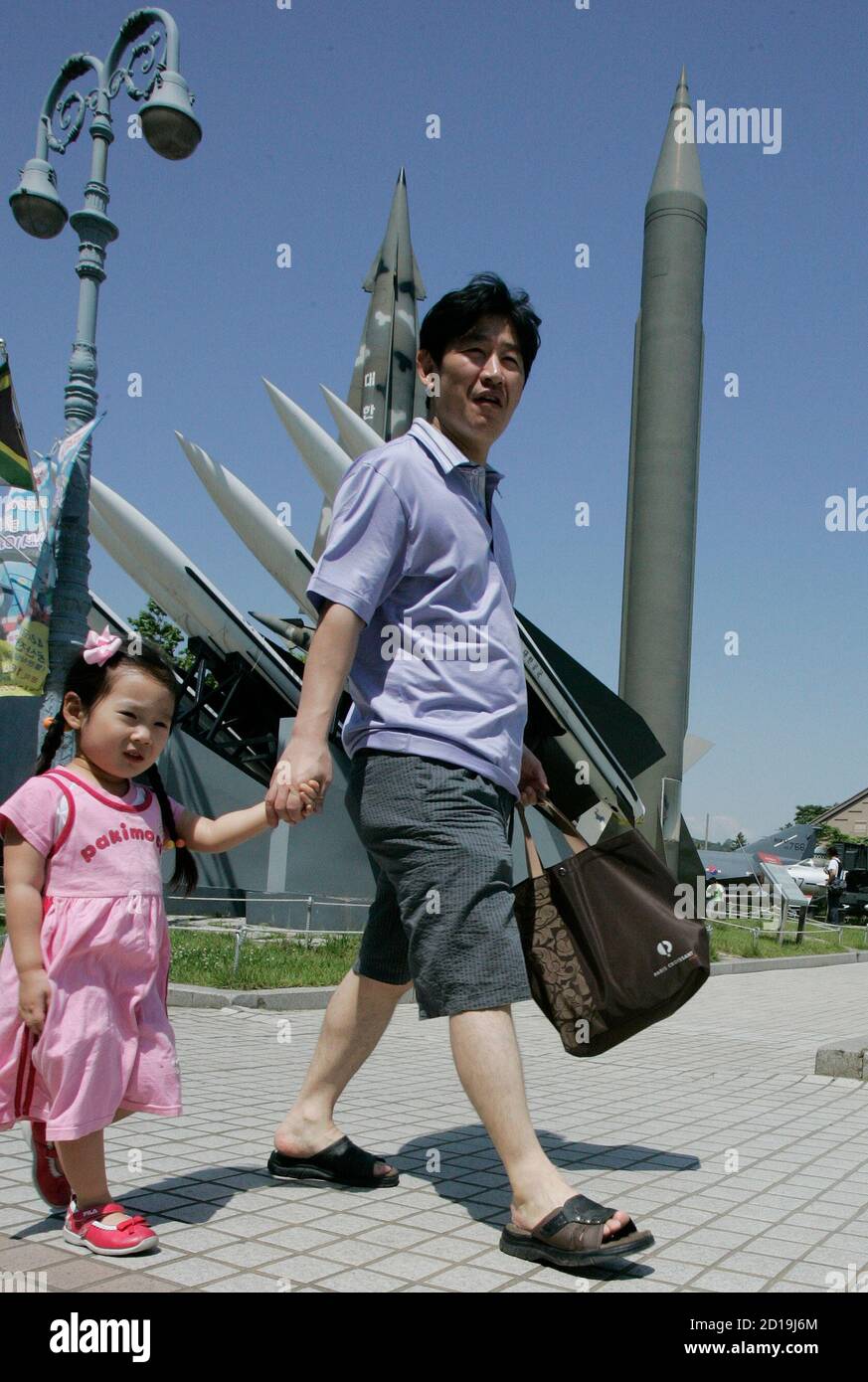 A man and his daughter walk past models of a North Korean Scud-B missile  (1st R) and South Korean missiles at the Korean War Memorial Museum in Seoul  May 31, 2009. U.S.