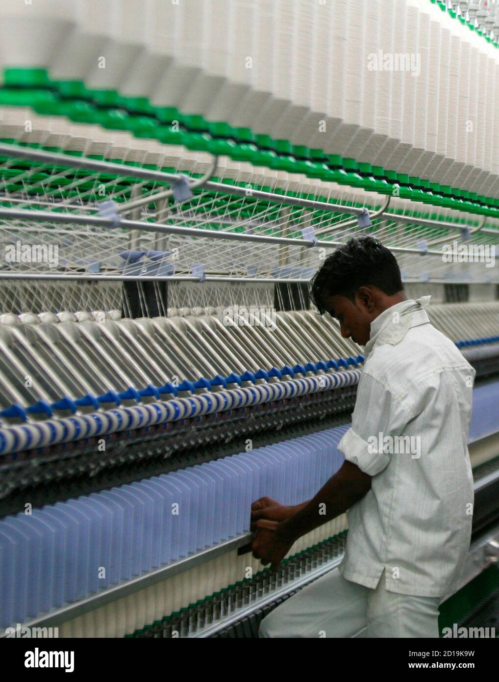 An employee works inside the Century Textiles and Industries Ltd. mill in Jhagadia village in the western Indian state of Gujarat October 22, 2009. Indian mill demand is likely to be boosted by an ongoing recovery in textile and apparel consumption in developed economies. REUTERS/Amit Dave (INDIA BUSINESS EMPLOYMENT) Stock Photo