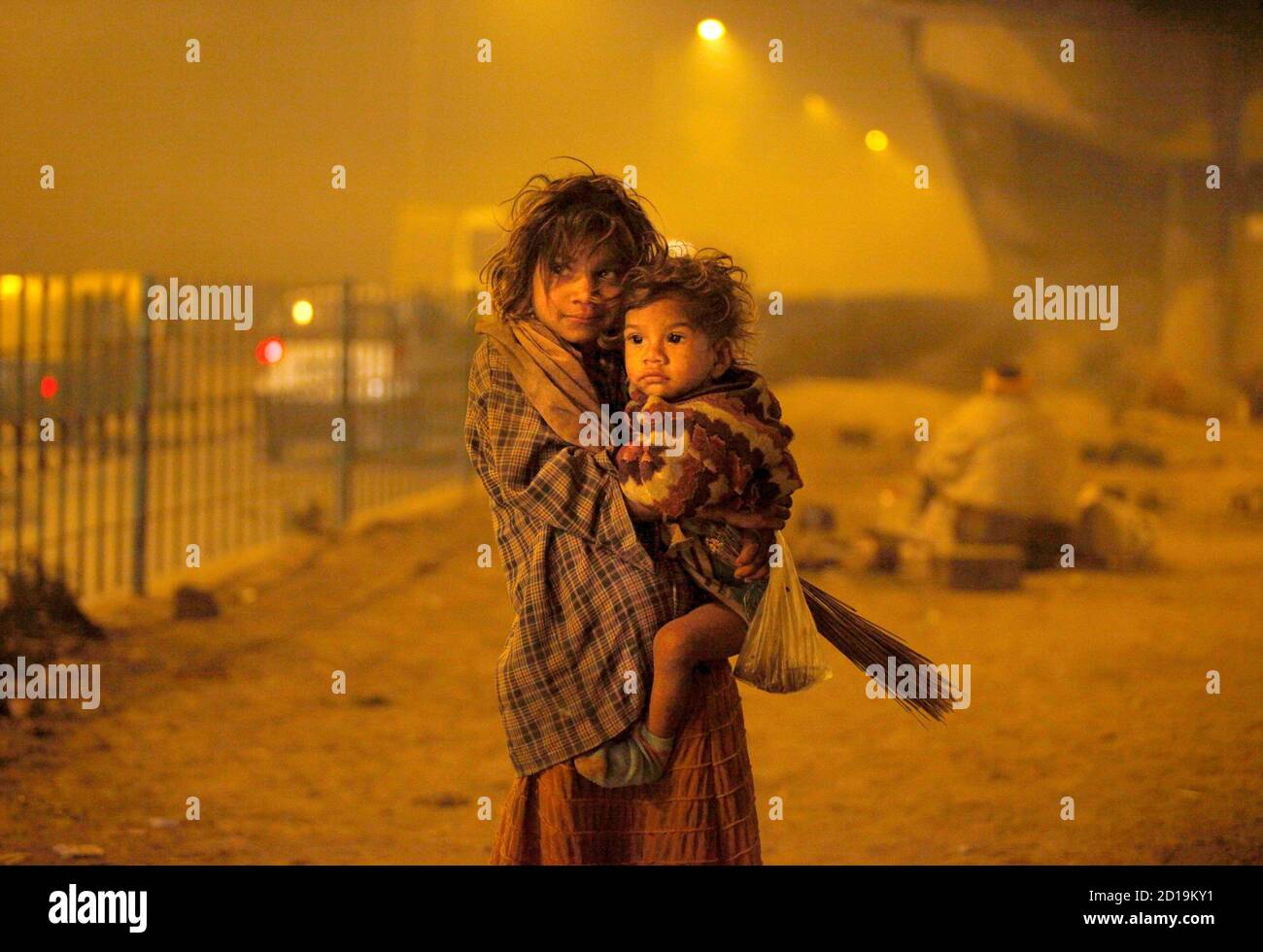 Homeless children arrive to sleep under a flyover in New Delhi January 21, 2010. The Supreme Court chided the Delhi government to provide night shelters with blankets, water and mobile toilets to all homeless in the capital, local media reported. REUTERS/Reinhard Krause (INDIA - Tags: SOCIETY) Stock Photo