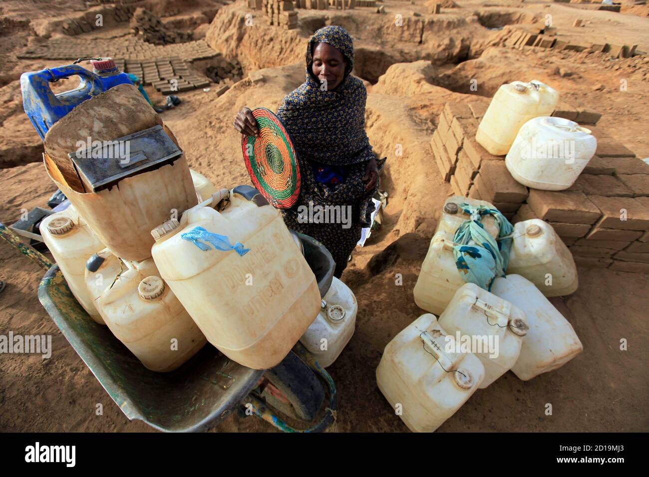 A displaced Sudanese woman prepares her containers in search of water at the Abu Shouk IDP (internally displaced persons) camp in Al Fasher, northern Darfur April 8, 2010. REUTERS/Zohra Bensemra (SUDAN - Tags: SOCIETY) Stock Photo