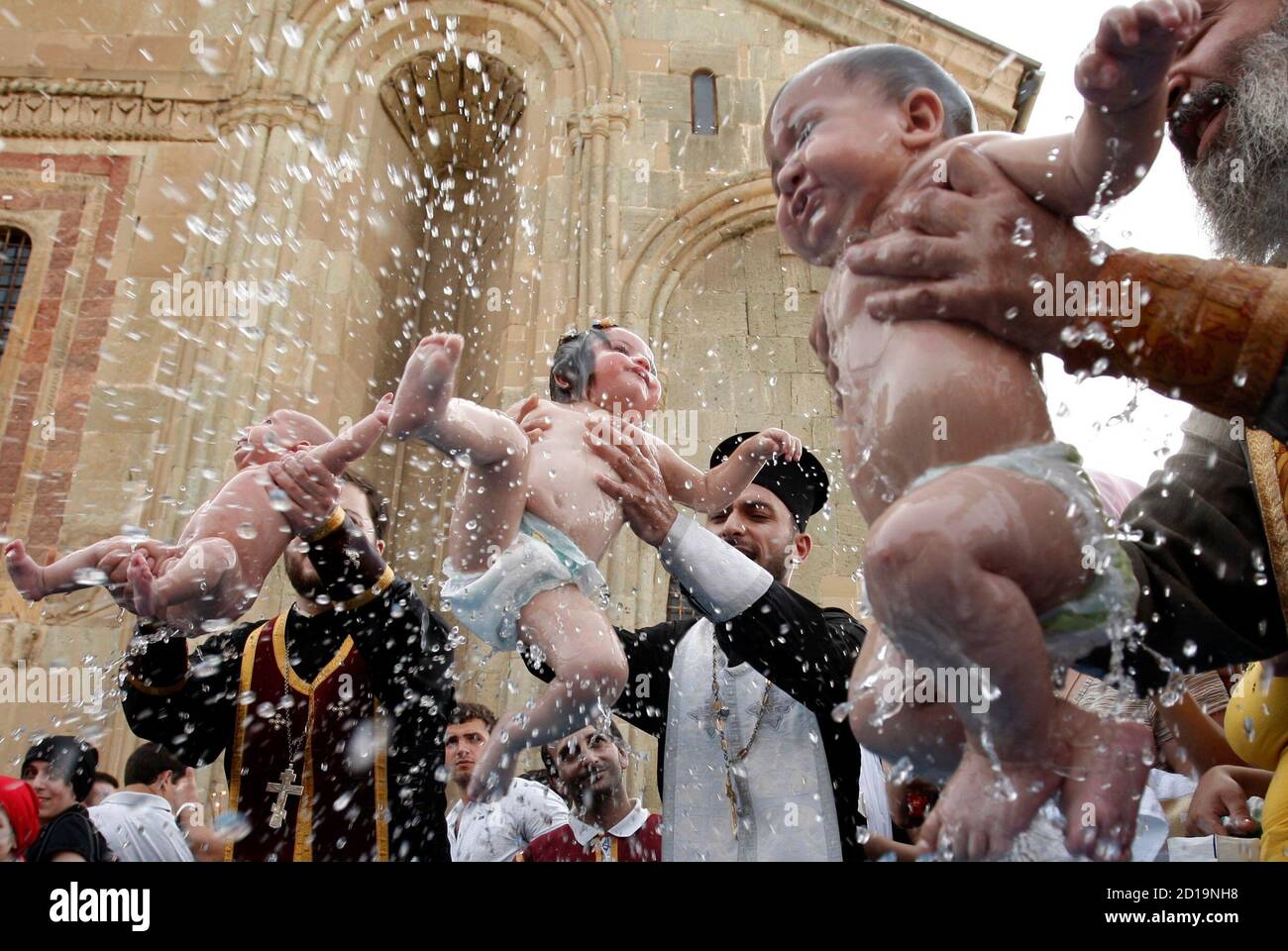 Children are baptized during a mass baptism ceremony in the town of Mtskheta outside Tbilisi, July 13, 2010. About 700 children were baptized by the Georgian Orthodox church during the 12th mass baptism ceremony led by Patriarch Ilia II.  REUTERS/David Mdzinarishvili  (GEORGIA - Tags: RELIGION IMAGES OF THE DAY) Stock Photo