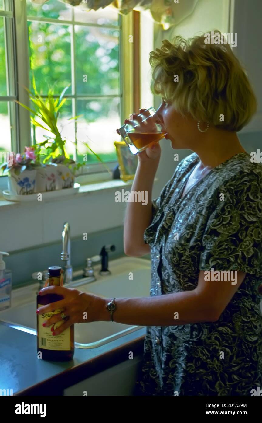 Female Alcoholic drinks liquor alone in home Stock Photo