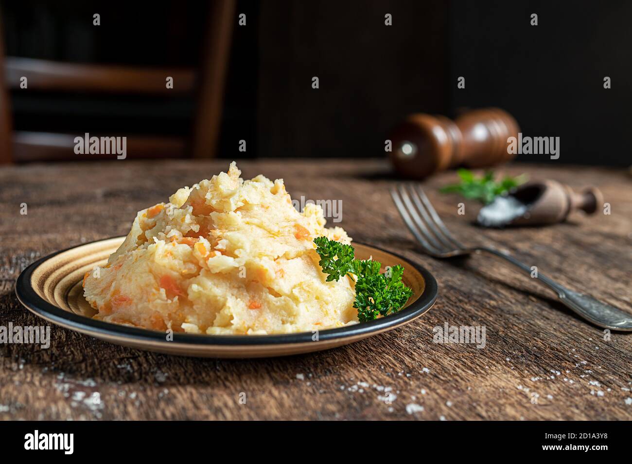 Mashed parsnips with potatoes and carrots on a dark wooden background close-up. Delicious and healthy vegetarian food rich in vitamins and minerals. Stock Photo