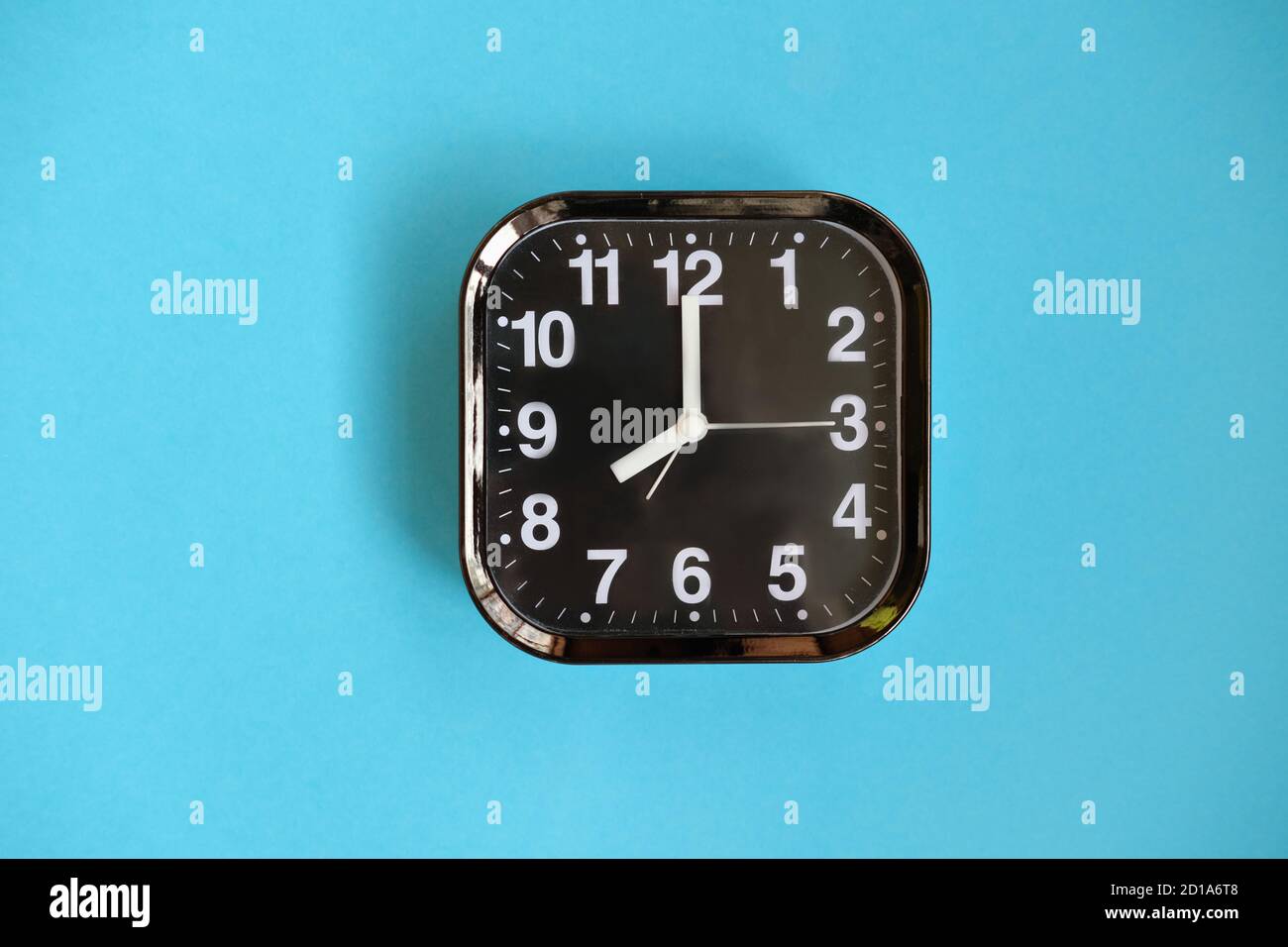 black modern alarm clock on blue background. good morning concept. wake up at eight o'clock