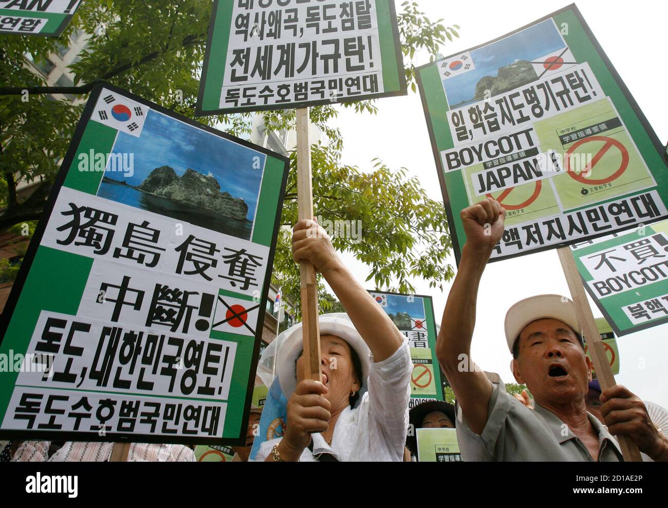 Protesters chant slogans at a demonstration against Japan's sovereignty claim over a group of desolate volcanic islets Seoul and Pyongyang call Dokdo and Tokyo calls Takeshima, in front of Japanese embassy in Seoul July 15, 2008. South Korea's coastguard said on Tuesday it had stepped up patrols near the islands, a day after Seoul recalled its ambassador in anger at new Japanese claims to the rocky outcrops. On Monday, Tokyo said it had told Seoul that it would refer in a middle school teaching guide to the islands as Japanese territory. A sign (L) reads "Stop robbing Dokdo. Dokdo, South Korea Stock Photo