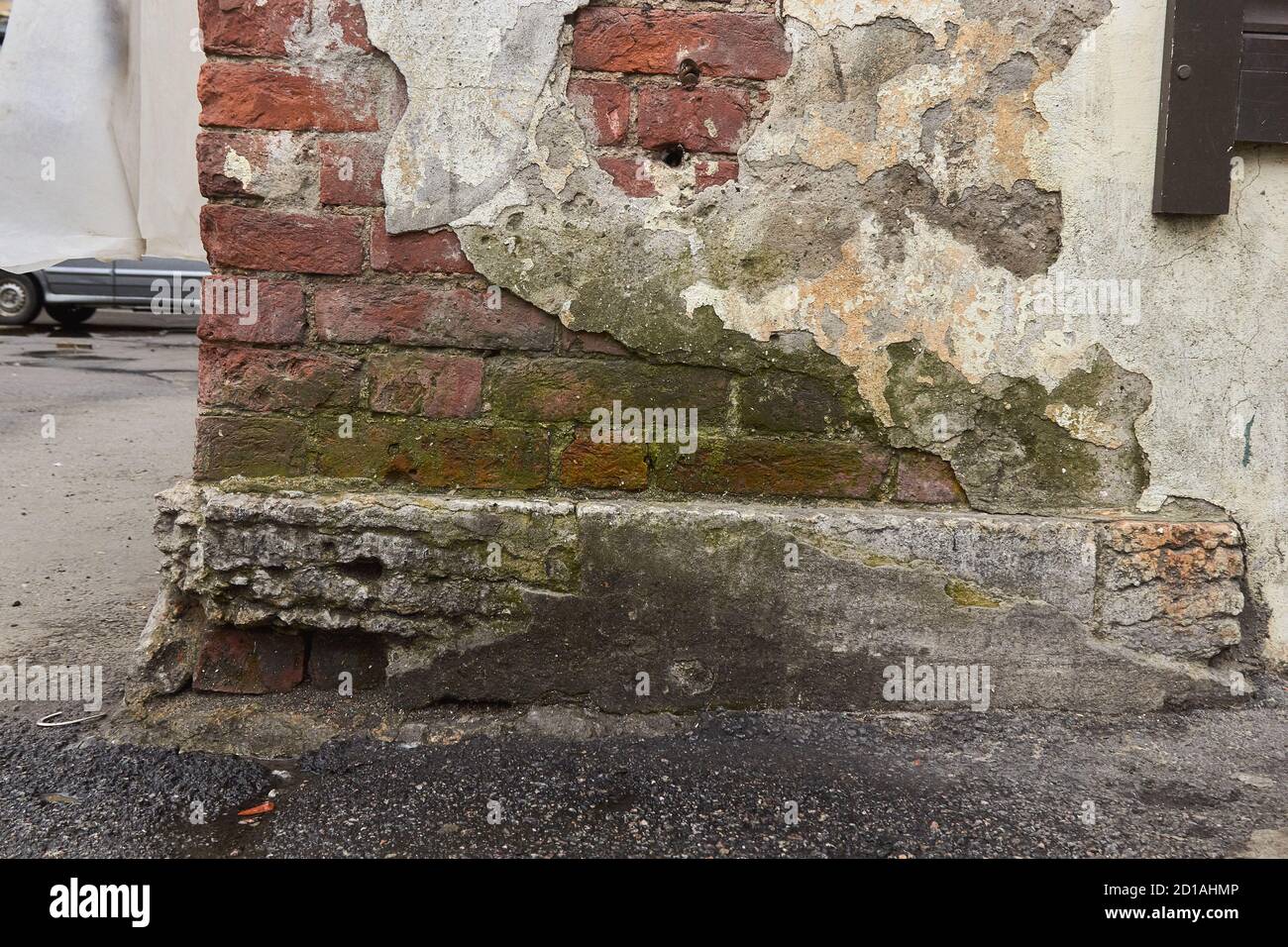 destroyed brick wall with fallen off plaster. Stock Photo
