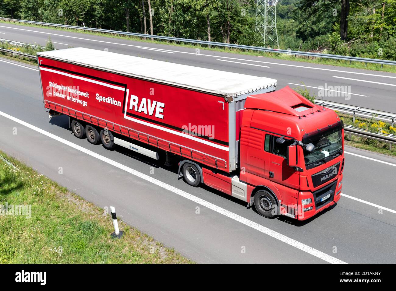 RAVE MAN TGX truck with curtainside trailer on motorway. Stock Photo
