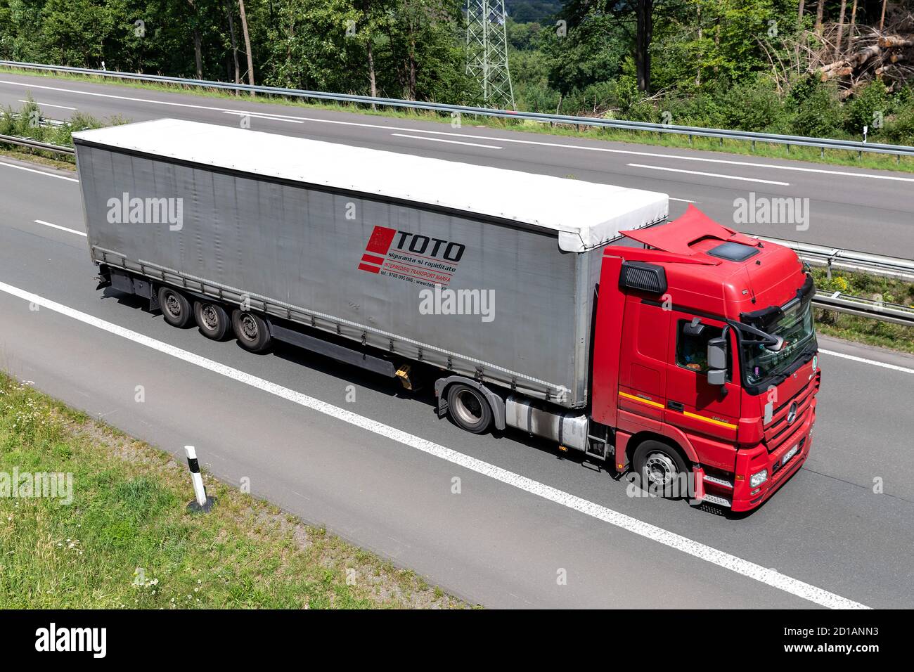 TOTO Mercedes-Benz Actros truck with curtainside trailer on motorway. Stock Photo