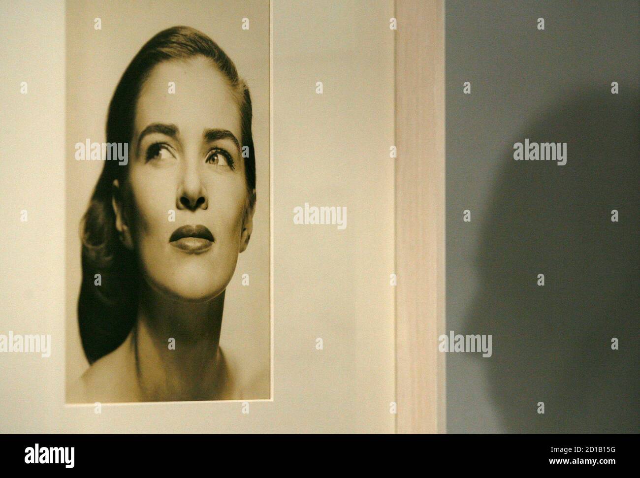 A visitor's shadow is cast beside a photograph by Richard Avedon of model Anne Theophane Graham during the exhibition 'Theo by Richard Avedon' in Rome January 31, 2009. Miniature stills of the American model posing in jeweled Dior gowns or a Balenciaga jacket are among dozens of previously unseen photos by famed photographer Avedon that went on display in Rome. The mostly black and white fashion shoot frames were found in an old trunk belonging to the late model.  REUTERS/Alessia Pierdomenico (ITALY) Stock Photo