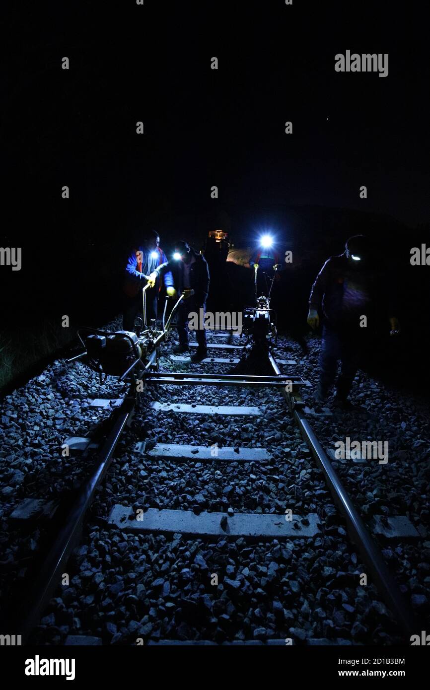 Rail destressing with power wrench before exothermic welding at night