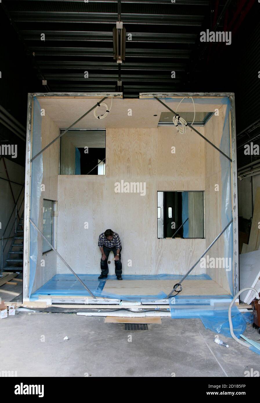 A worker inspects the inside of The Mirrorcube on the construction site of Treehotel in the Swedish village of Harads, July 5, 2010. A lofty new hotel concept is set to open in a remote village in northern Sweden, which aims to elevate the simple treehouse into a world-class destination for design-conscious travellers. Treehotel, located in Harads about 60 km south of the Arctic Circle, will consist of four rooms when it opens on July 17th: The Cabin, The Blue Cone, The Nest and The Mirrorcube. Picture taken July 5, 2010.     To match Reuters Life! SWEDEN-TREEHOTEL/    REUTERS/Matt Cowan    (S Stock Photo
