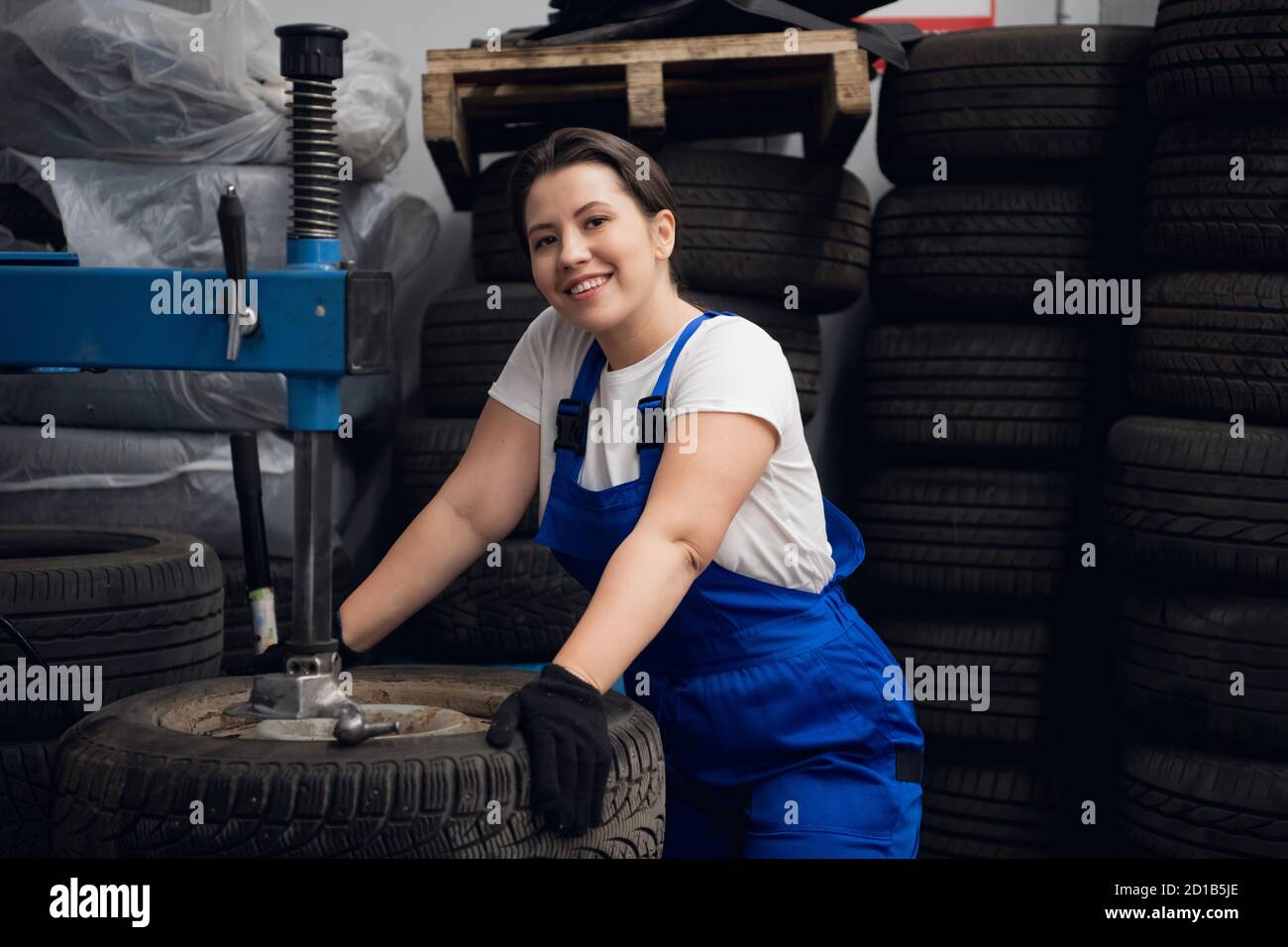 Female engineer is using a press and looking at the camera Stock Photo