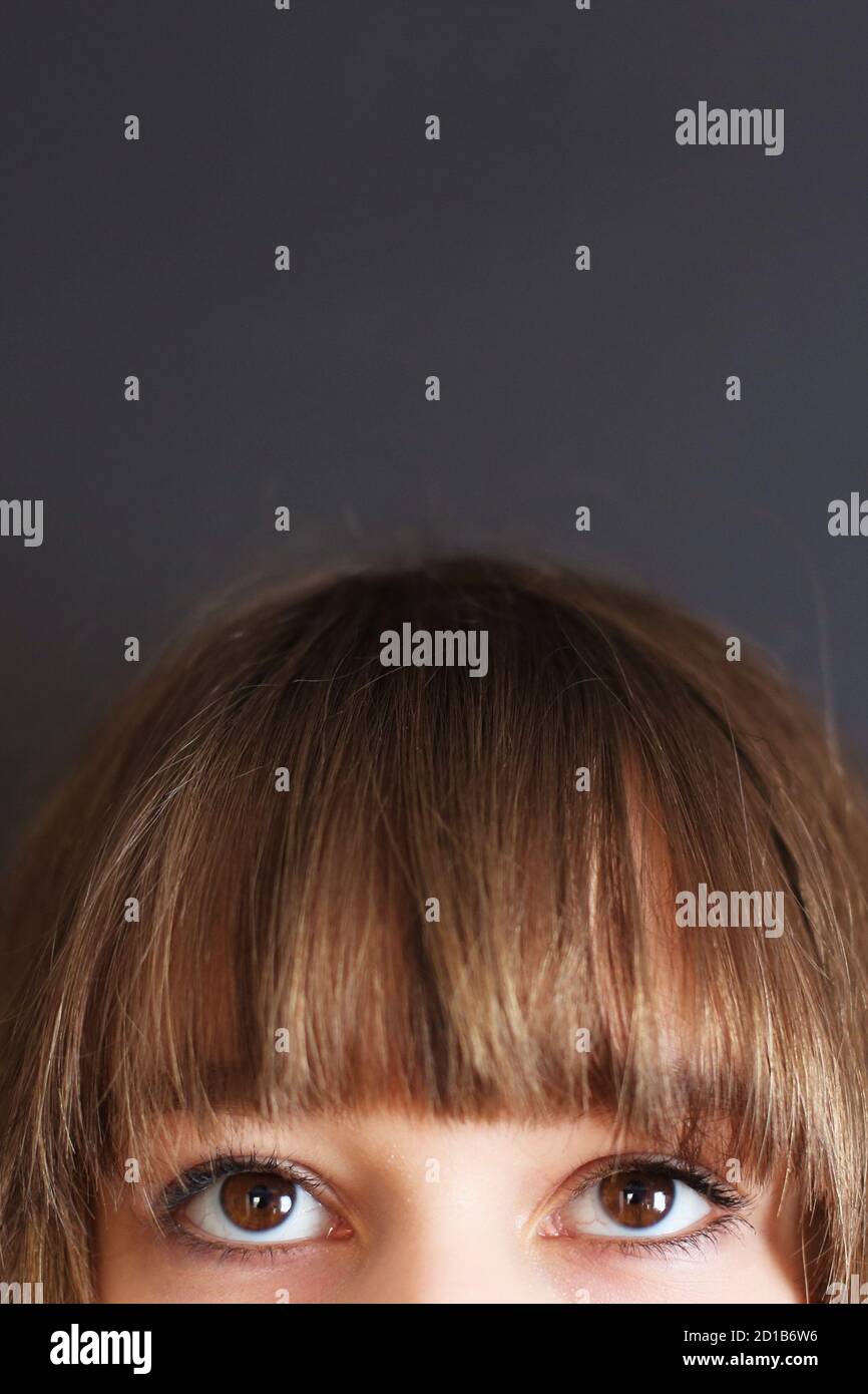 Close up of the bangs and eyes of a teen girl. Stock Photo