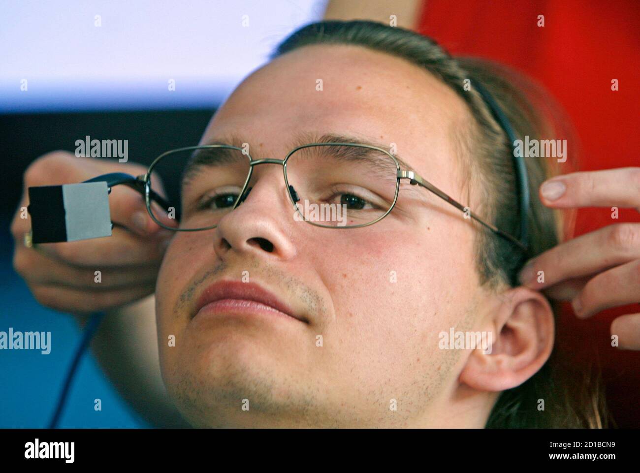 Handicapped student Michal Kabat is assisted with adjusting a camera which  lets him control a personal computer by moving his eyes and head in Prague,  September 2, 2008. The system called I4Control